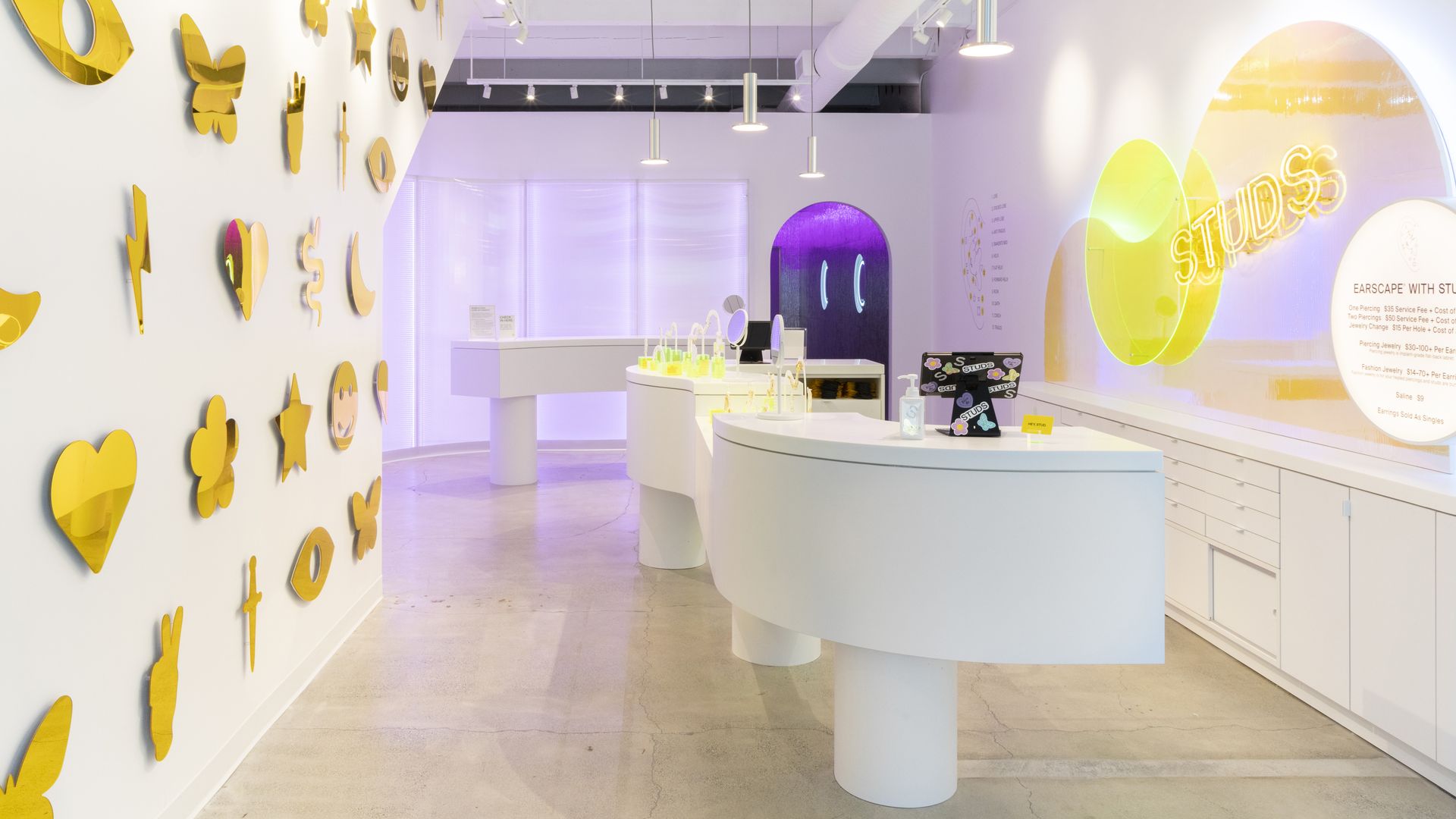 inside the Studs piercing studio with gold emoticons