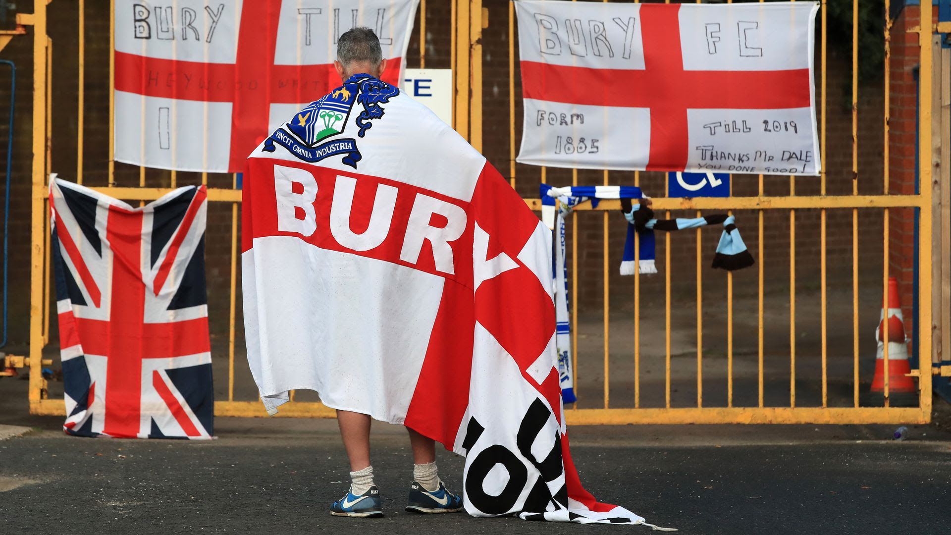A man standing in front of the now closed English soccer club Bury FC