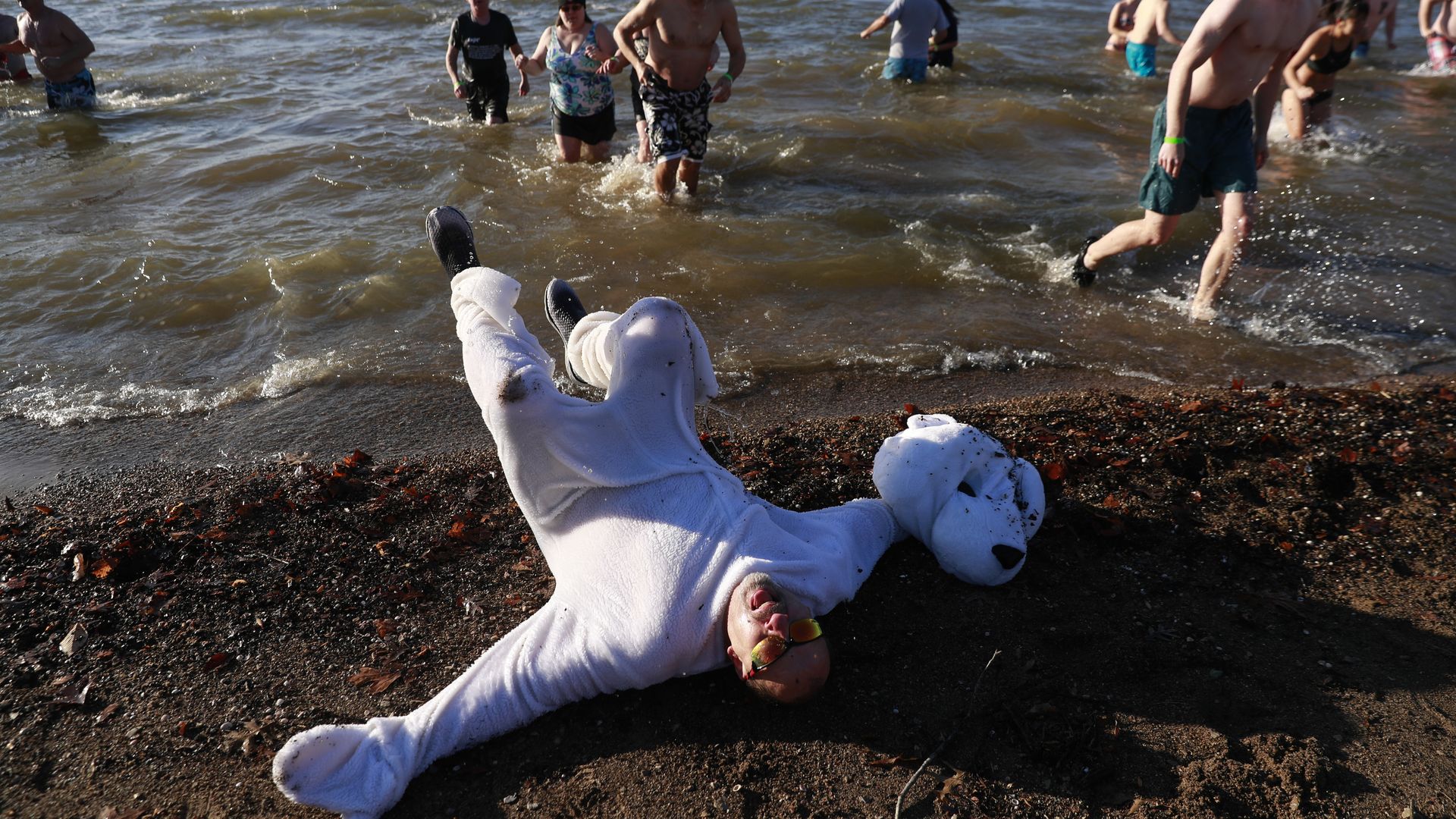 Participants run into Lake Monroe during the annual Polar Bear Plunge at Paynetown State Recreation Area before retreating on New Year's Day in Bloomington.