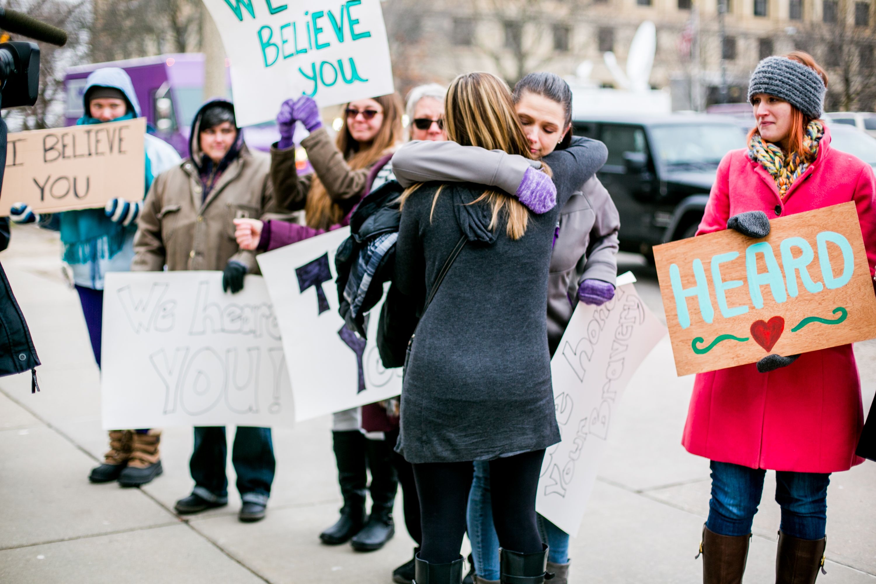 Women holding signs outside the courthouse