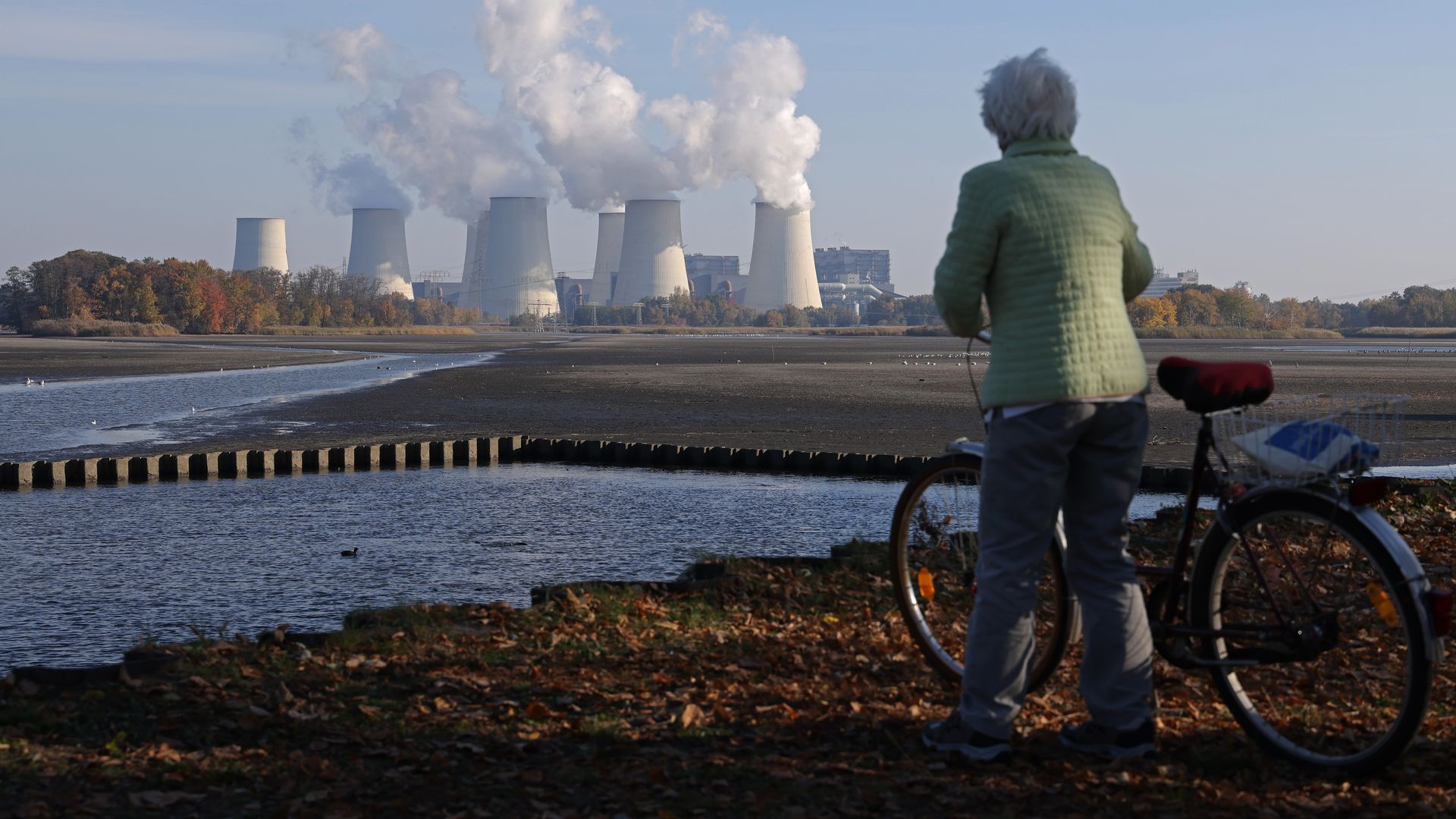 An elderly woman looks at the Jaenschwalde lignite coal-fired power plant, which is among the biggest single emitters of CO2 in Europe, on October 29, 2021 in Peitz, Germany. 