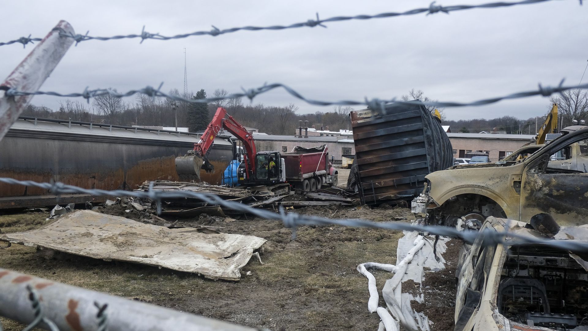 Photo of crews disposing of wreckage from a burnt train car