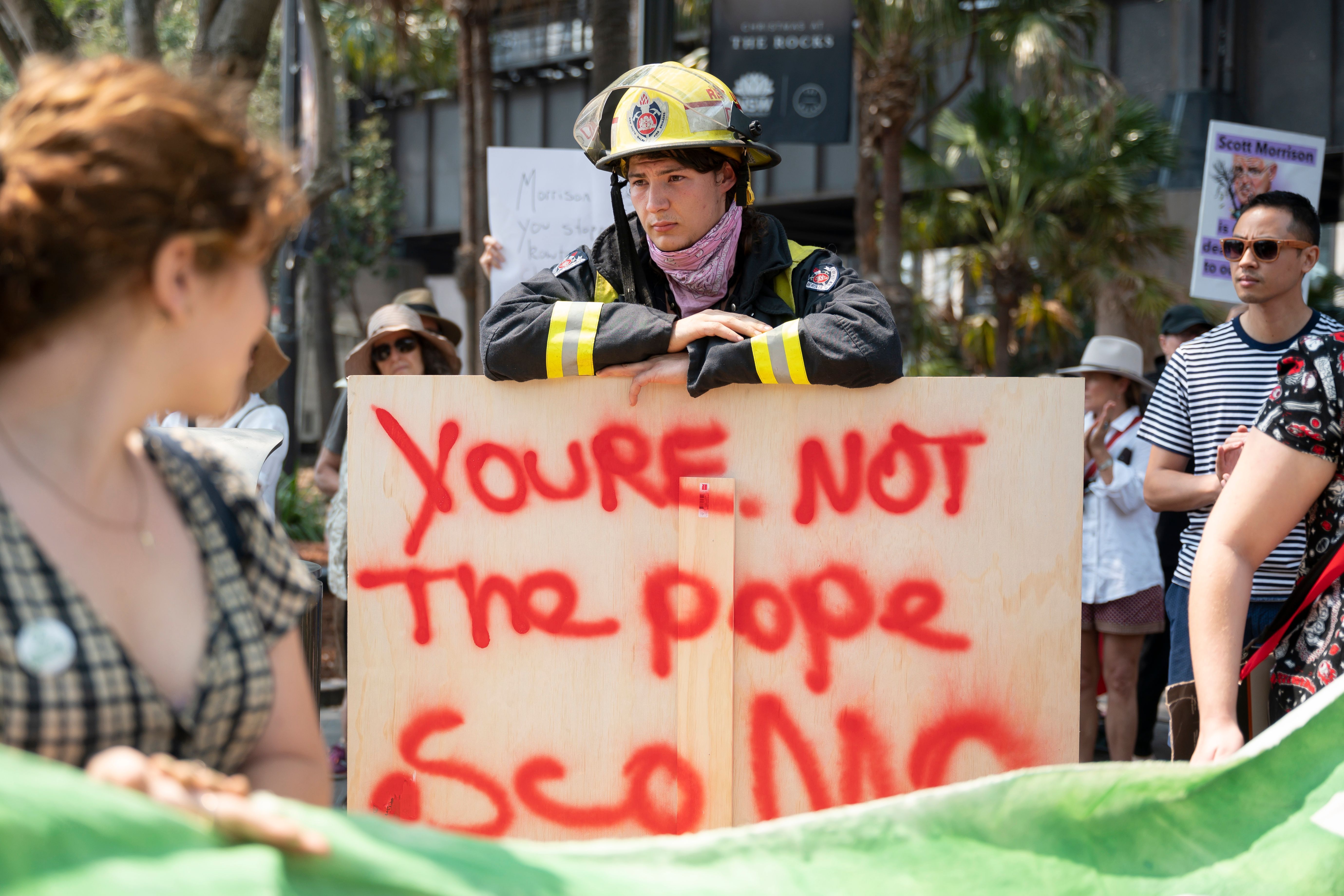 Demonstrators hold up placards during a climate protest rally in Sydney on December 21