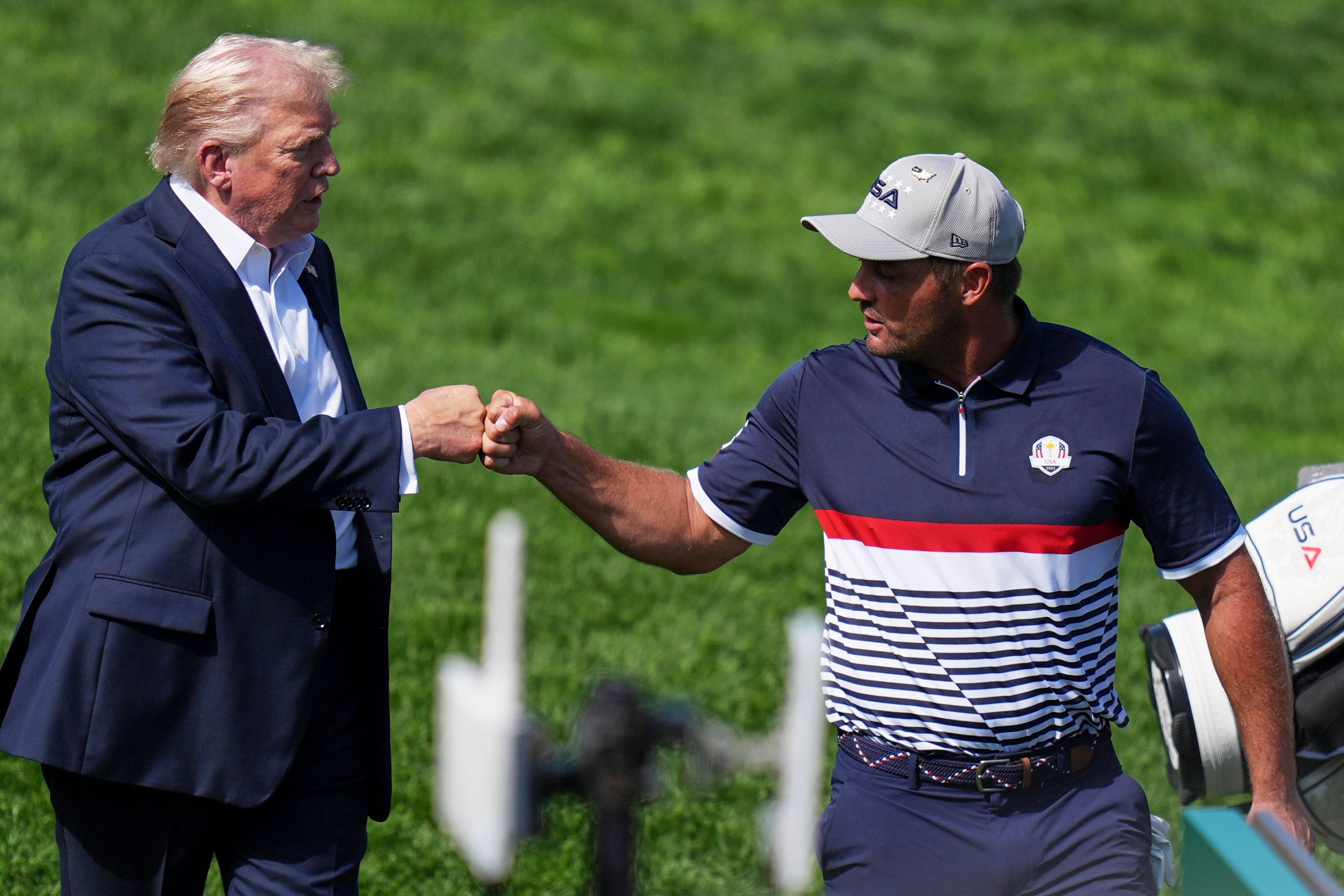 President Donald Trump greets United States' Bryson DeChambeau on the first hole at Bethpage Black golf course during the Ryder Cup golf tournament, Friday, Sept. 26, 2025, in Farmingdale, N.Y. (AP Photo/Seth Wenig)