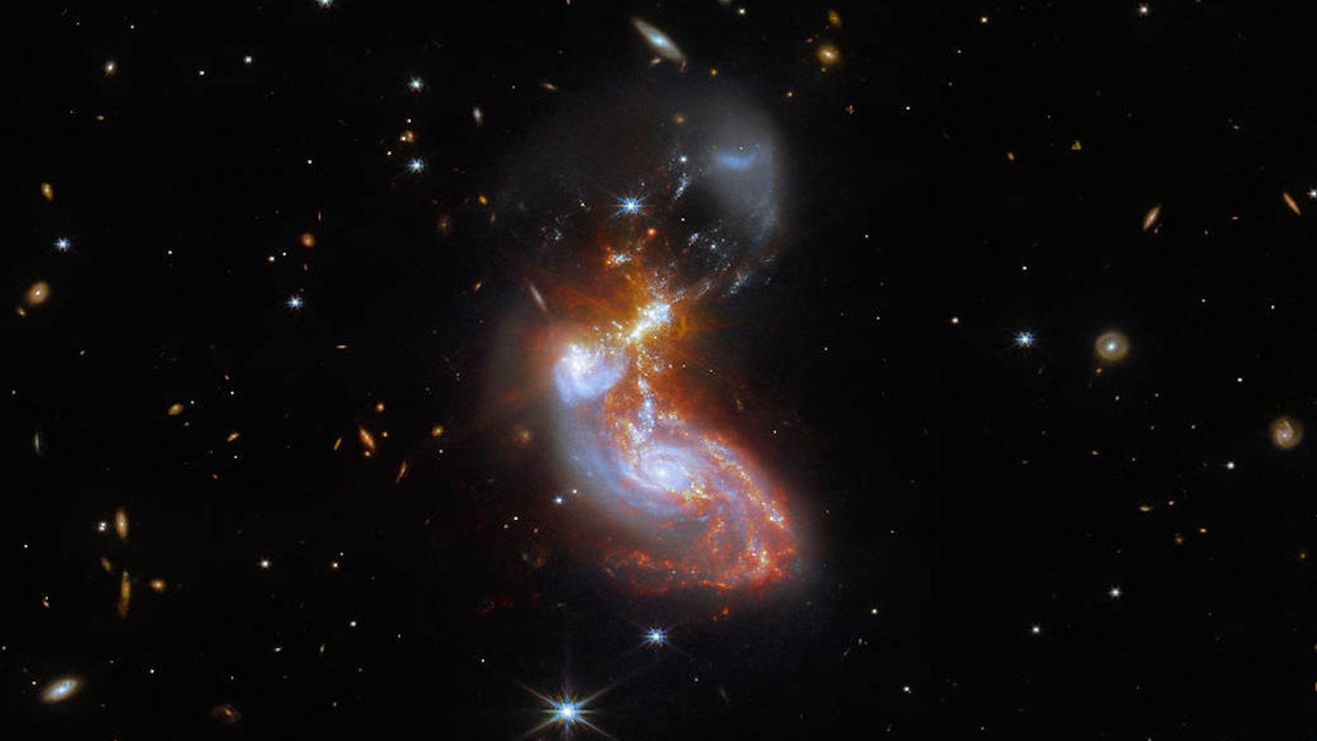 Two galaxies melting into one another and merging.