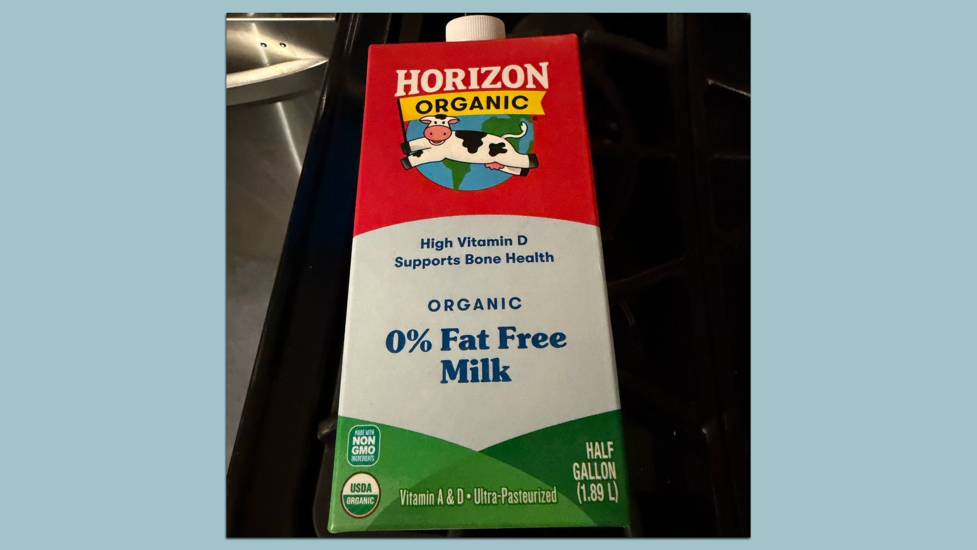 Front of a Horizon Organic milk carton with red top, white middle, and green bottom; features a cartoon cow logo and bold blue text reading 0% Fat Free Milk and High Vitamin D Supports Bone Health.