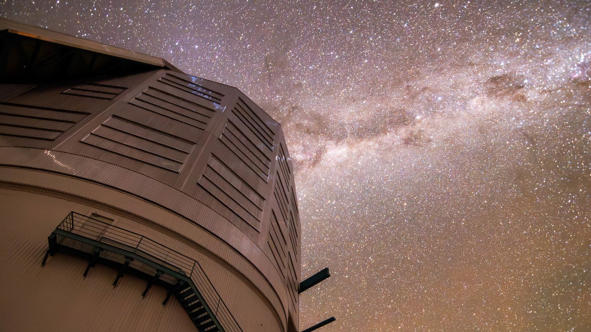 Stars dazzle against a milky mauve night sky above Rubin Observatory in Cerro Pachon, Chile.