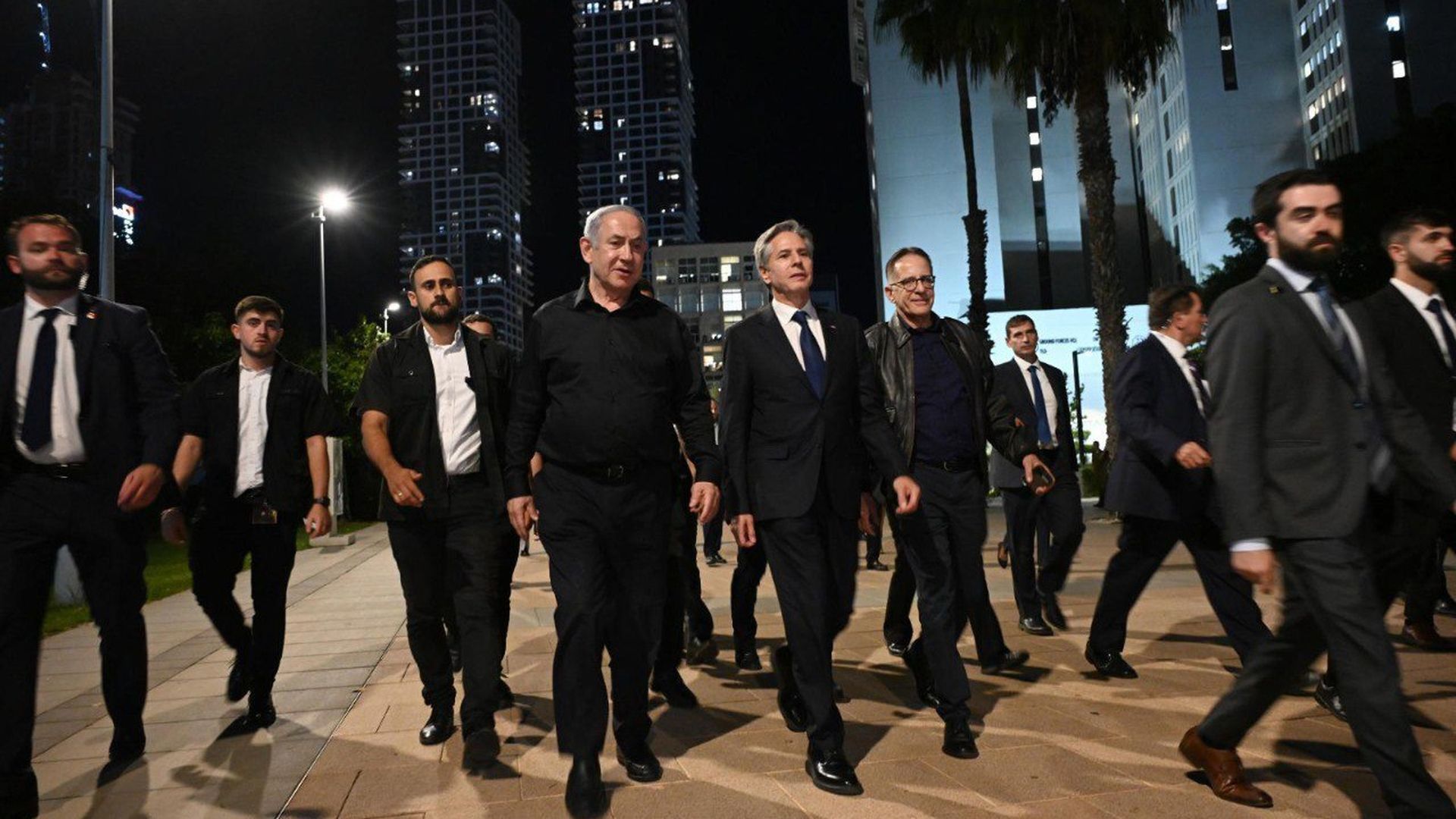 Israeli Benjamin Netanyahu, in all black, walks with U.S. Secretary of Antony Blinken and security personnel
