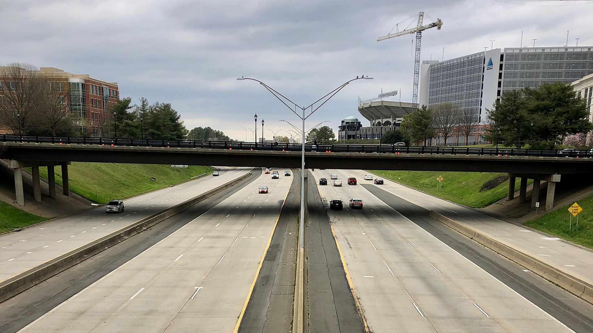 photo of I-277 in Charlotte with almost no traffic on the light-gray asphalt that spans eight lanes with a divided median