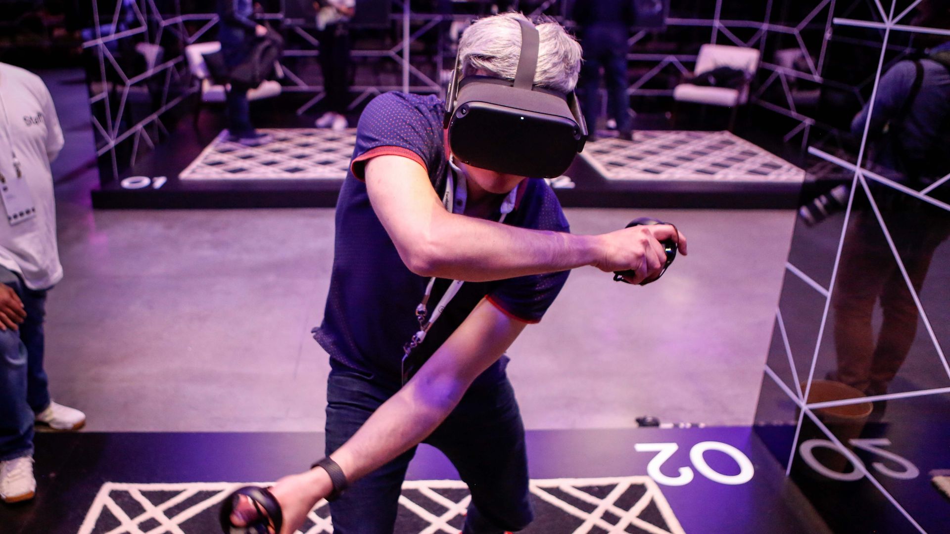 Photo of a person wearing a VR headset and gesticulating with two controllers 