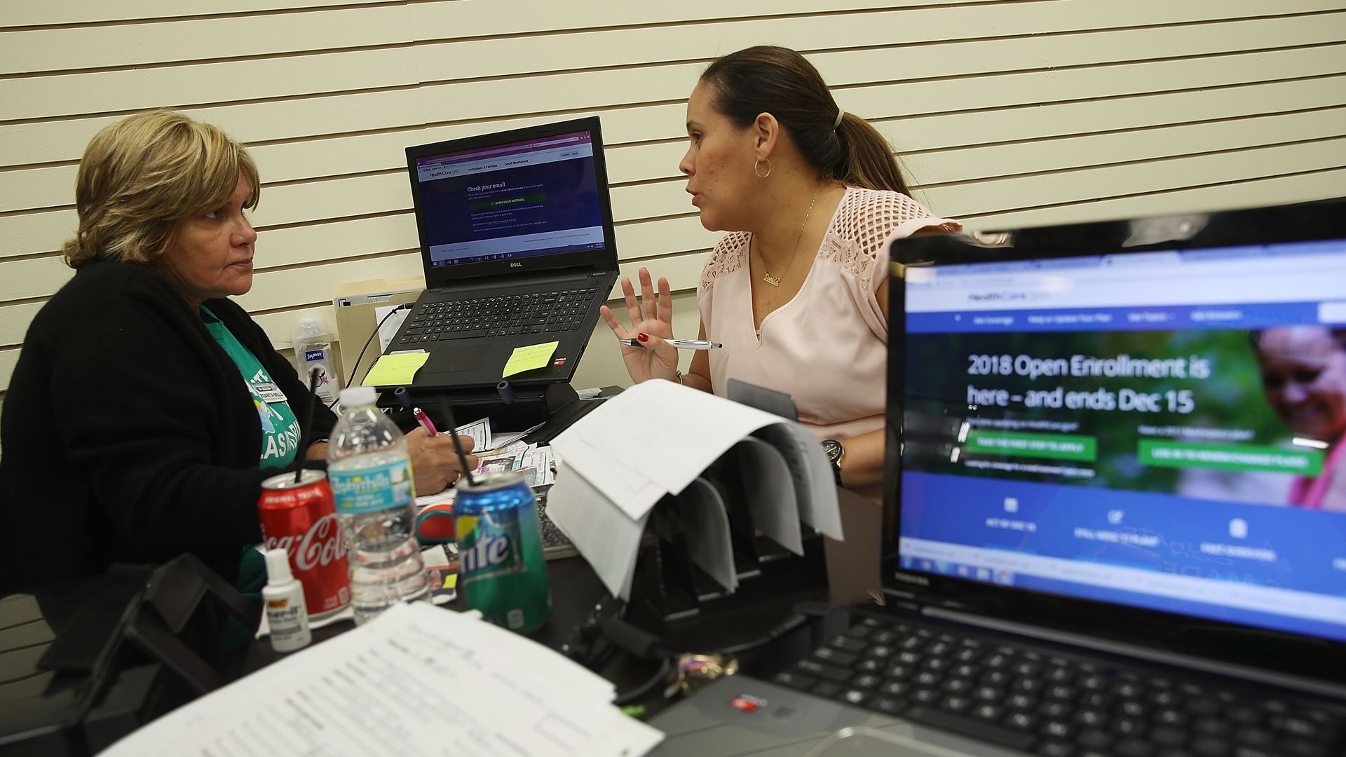 A health insurance broker helps a woman sign up for health insurance.