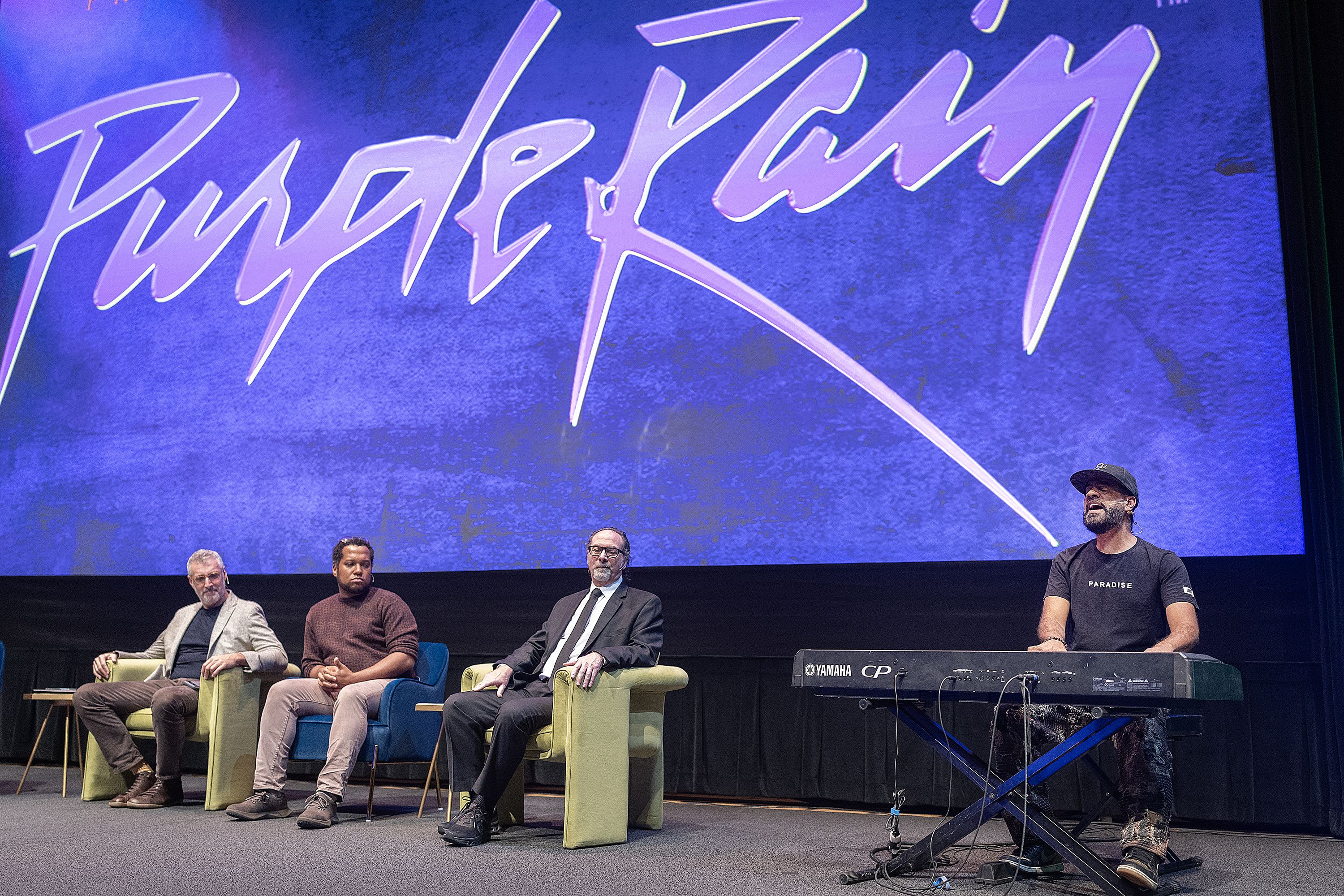 Orin Wolf, Branden Jacobs-Jenkins, Bobby Z and Jason Michael Webb(at the keyboards) sit on a stage with purple rain logo in the background
