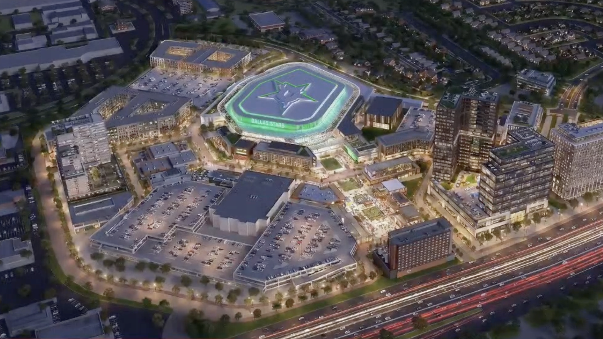 Aerial nighttime view of a large arena with a glowing green rim and star logo, labeled "DALLAS STARS," in a downtown complex surrounded by tall buildings, parking lots, and streaking city lights.