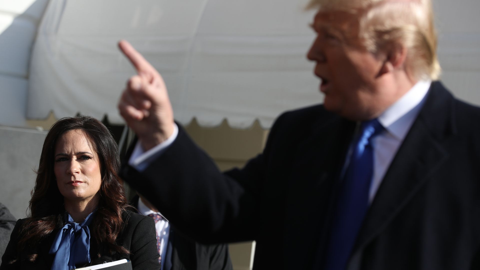 White House Press Secretary Stephanie Grisham (L) listens to U.S. President Donald Trump talk to reporters before he boards Marine One and departing the White House November 08, 2019 in Washington, DC.