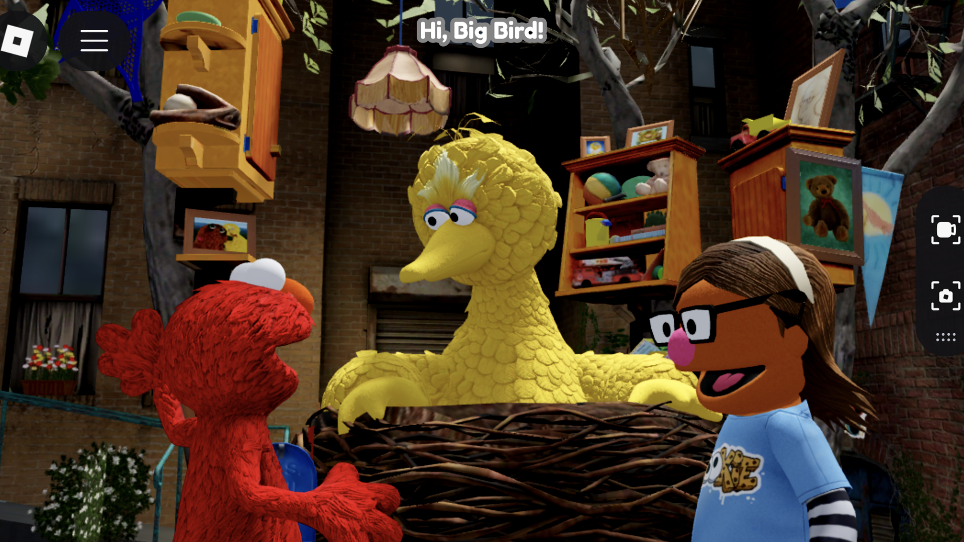 Red furry Elmo talks to yellow Big Bird in a large nest with a Muppet Avatar of Ina Fried person wearing glasses and a blue shirt nearby, set against a brick building with plants and hanging shelves.