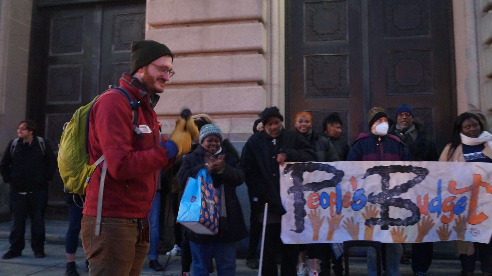 Organizer Jonathan Welle speaks at a PB Cle rally in January, dressed in winter gear on the steps of Cleveland City Hall