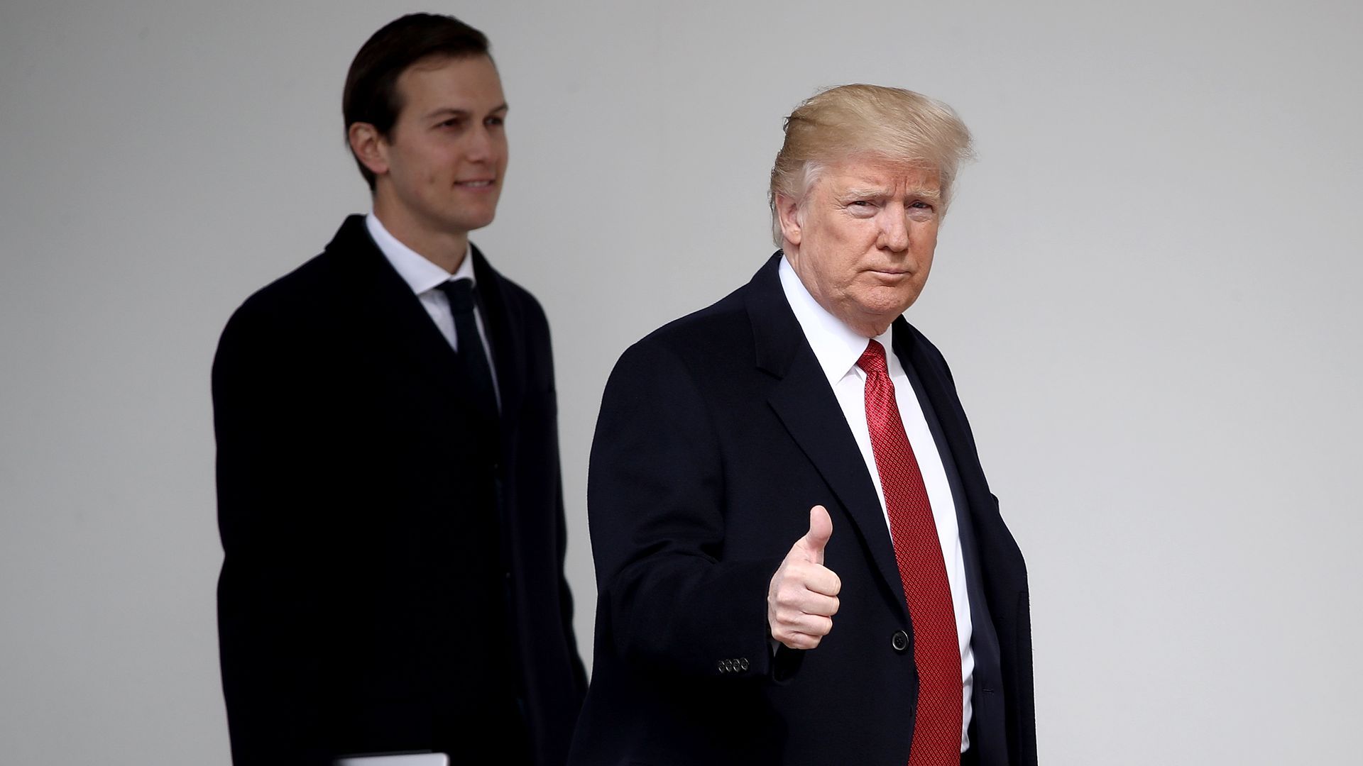 President Trump gives a thumbs up while walking alongside Jared Kushner