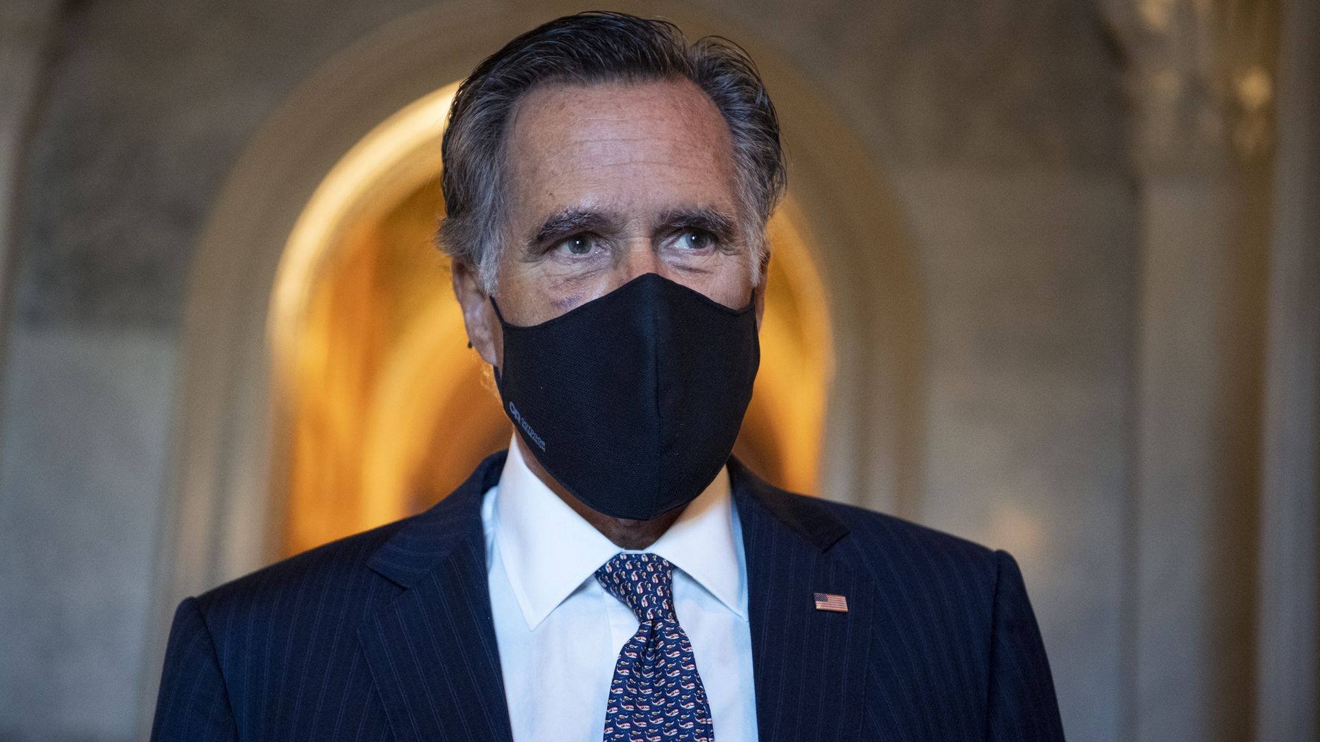 Mitt Romney wears a suit and face mask