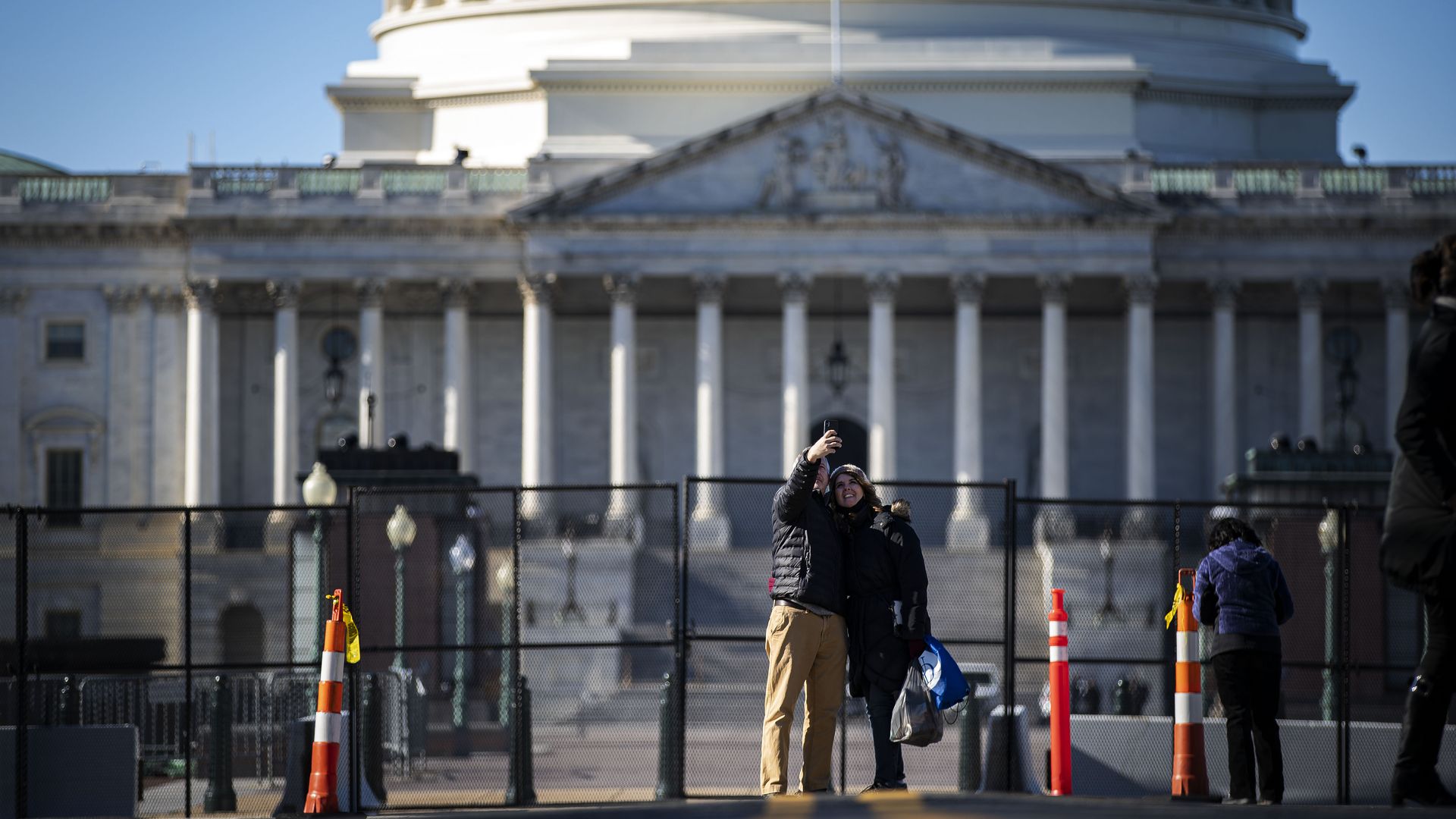 A couple is seen taking a selfie in front of a barricaded U.S. Capitol.