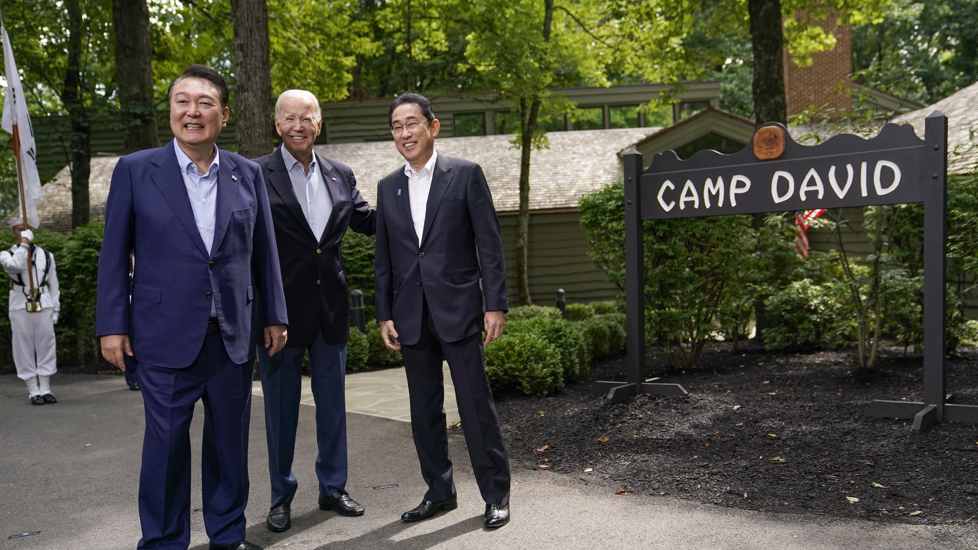 US President Joe Biden, center, greets Fumio Kishida, Japan's prime minister, right, and Yoon Suk Yeol, South Korea's president, left, during a trilateral summit at Camp David