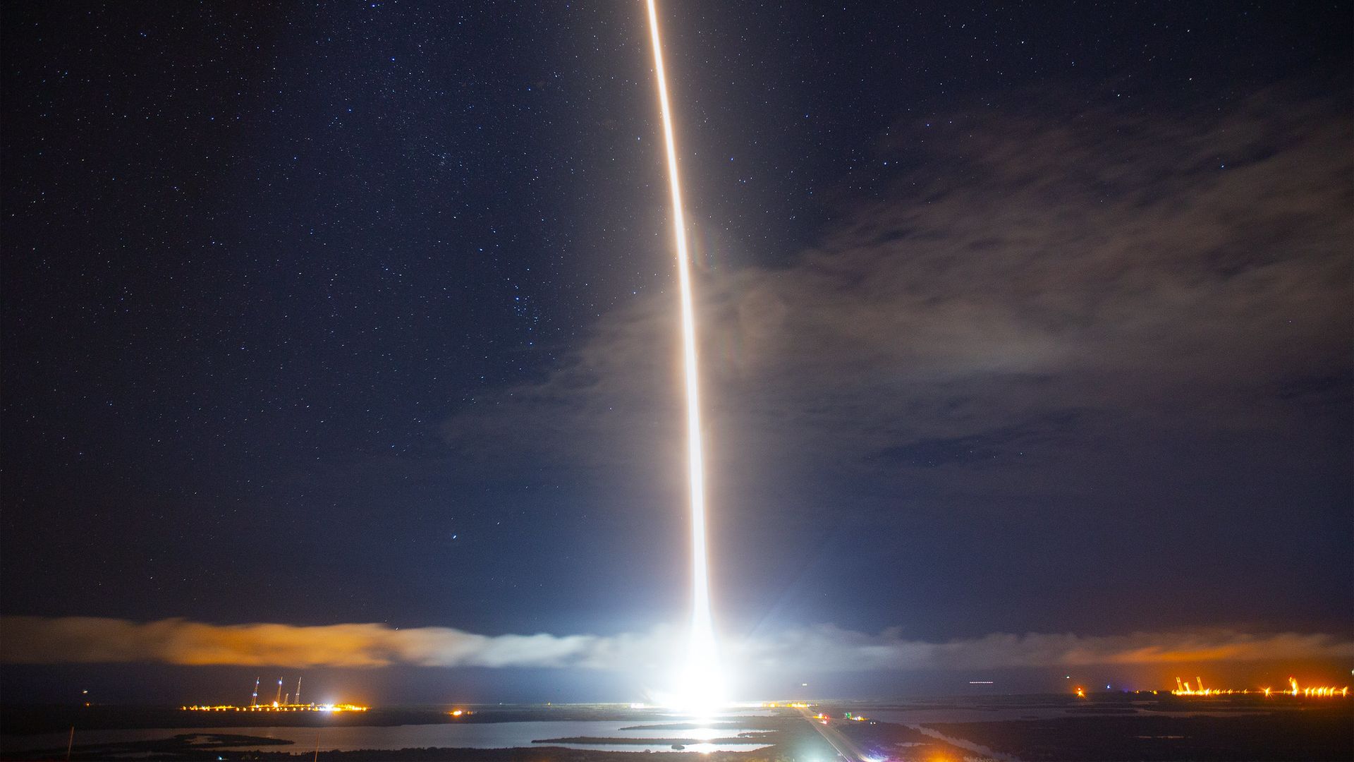 The streak of a rocket with stars in the background at night