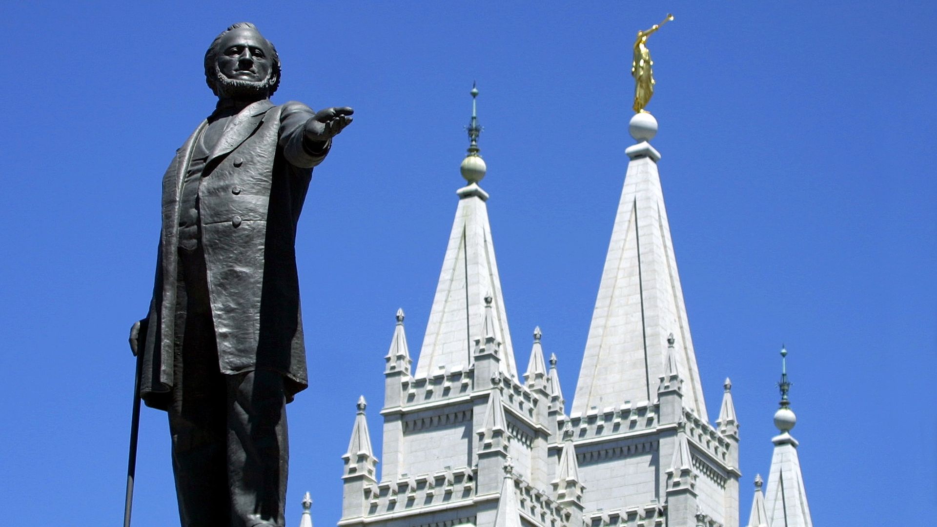  A statue of Brigham Young, second president of the Church of Jesus Christ of Latter Day Saints stands in the center of Salt Lake City with the Mormon Temple spires in the background 19 July 2001.