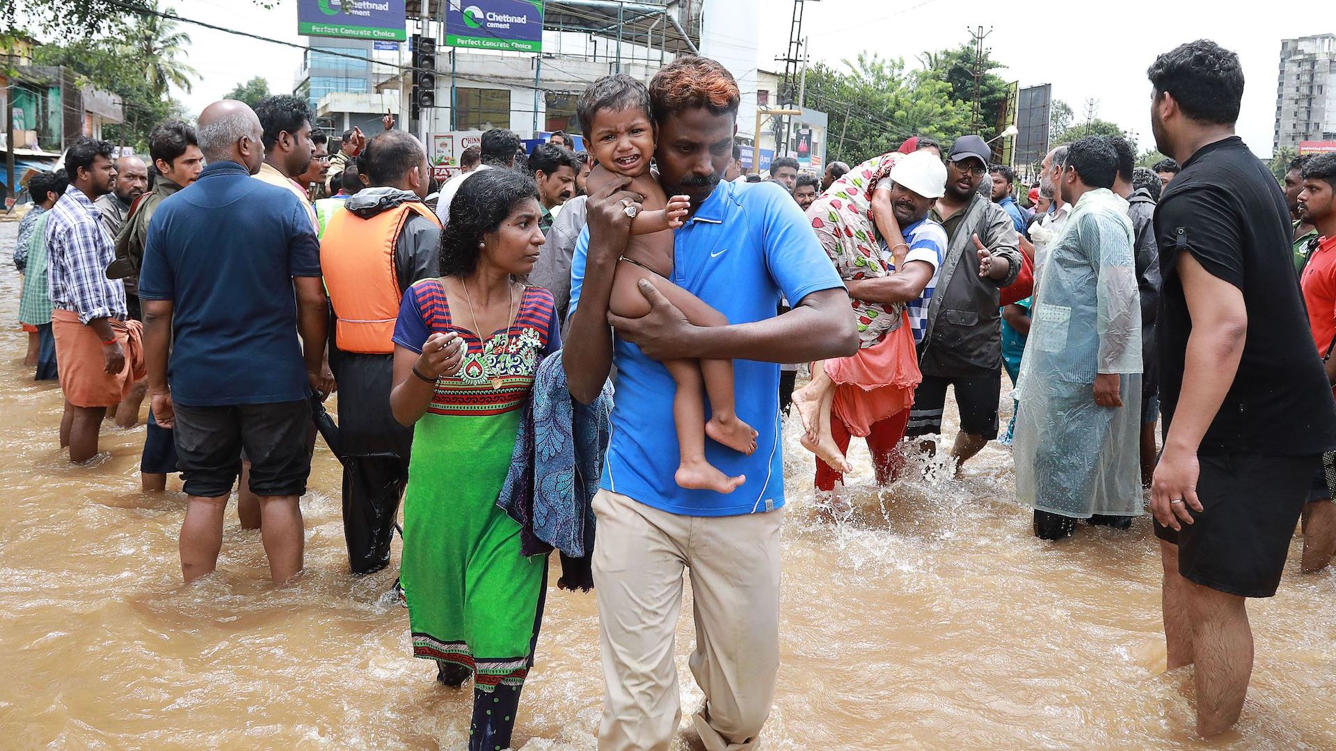 Indian volunteers and rescue personal evacuate local residents in a residential area at Aluva in Ernakulam district, in the Indian state of Kerala, on August 17, 2018.
