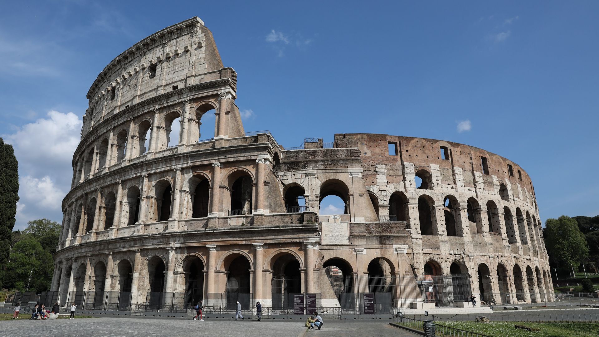 People enjoy beautiful weather outside the Colosseum in Rome, Italy, April 2