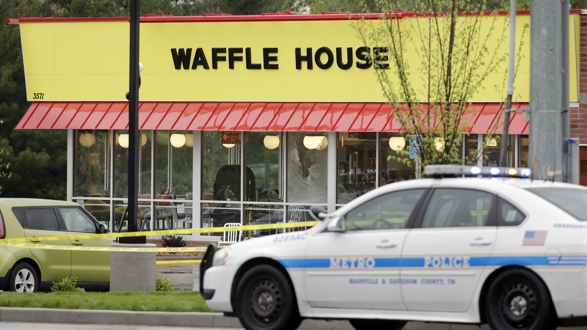 A photo of a waffle house restaurant with a police cruiser parked in front.
