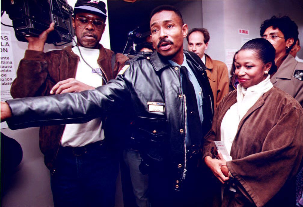 Photo of a police officer clearing way for woman to vote