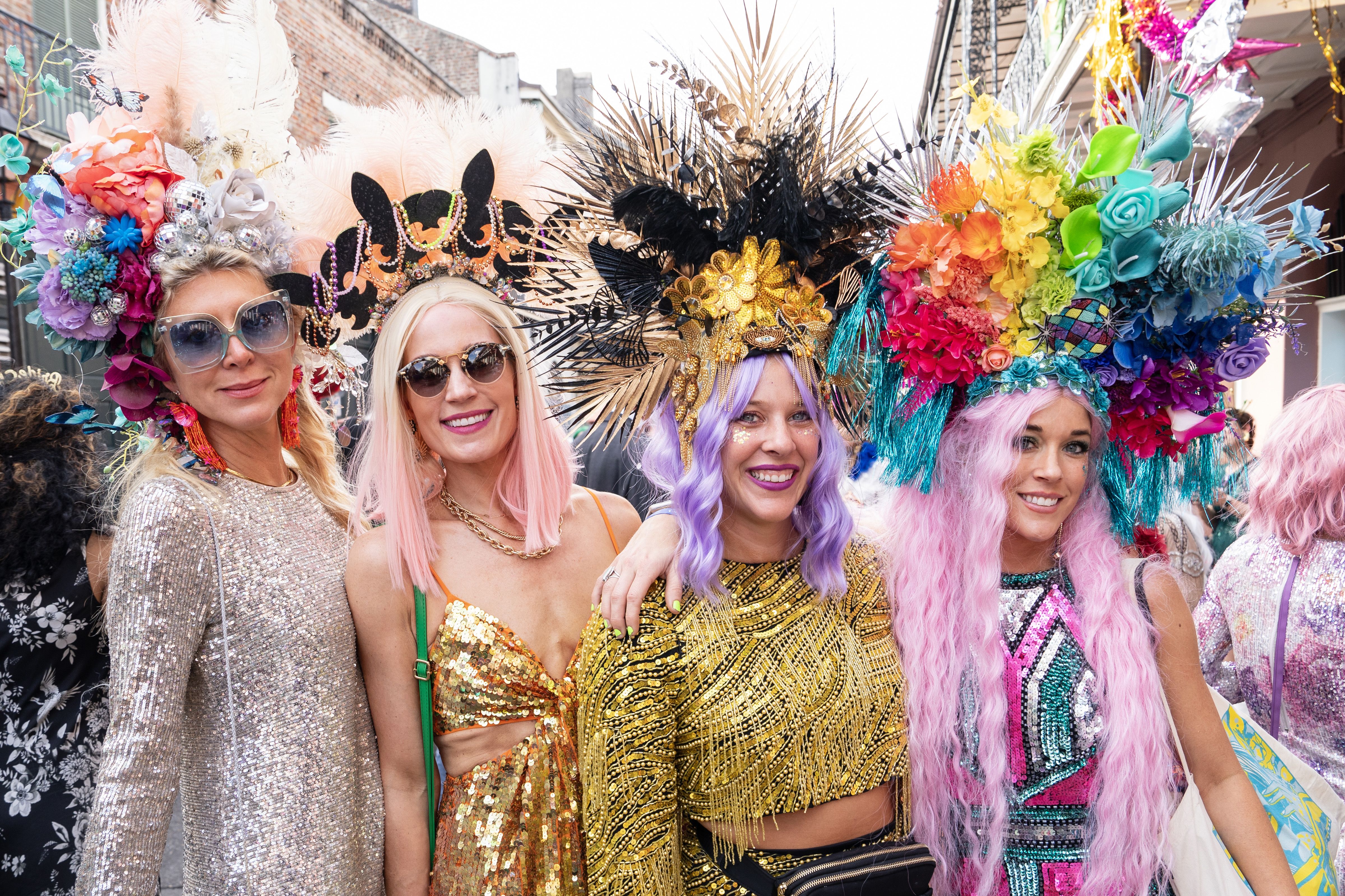 Photo shows a group of women wearing sequins and big headdresses.