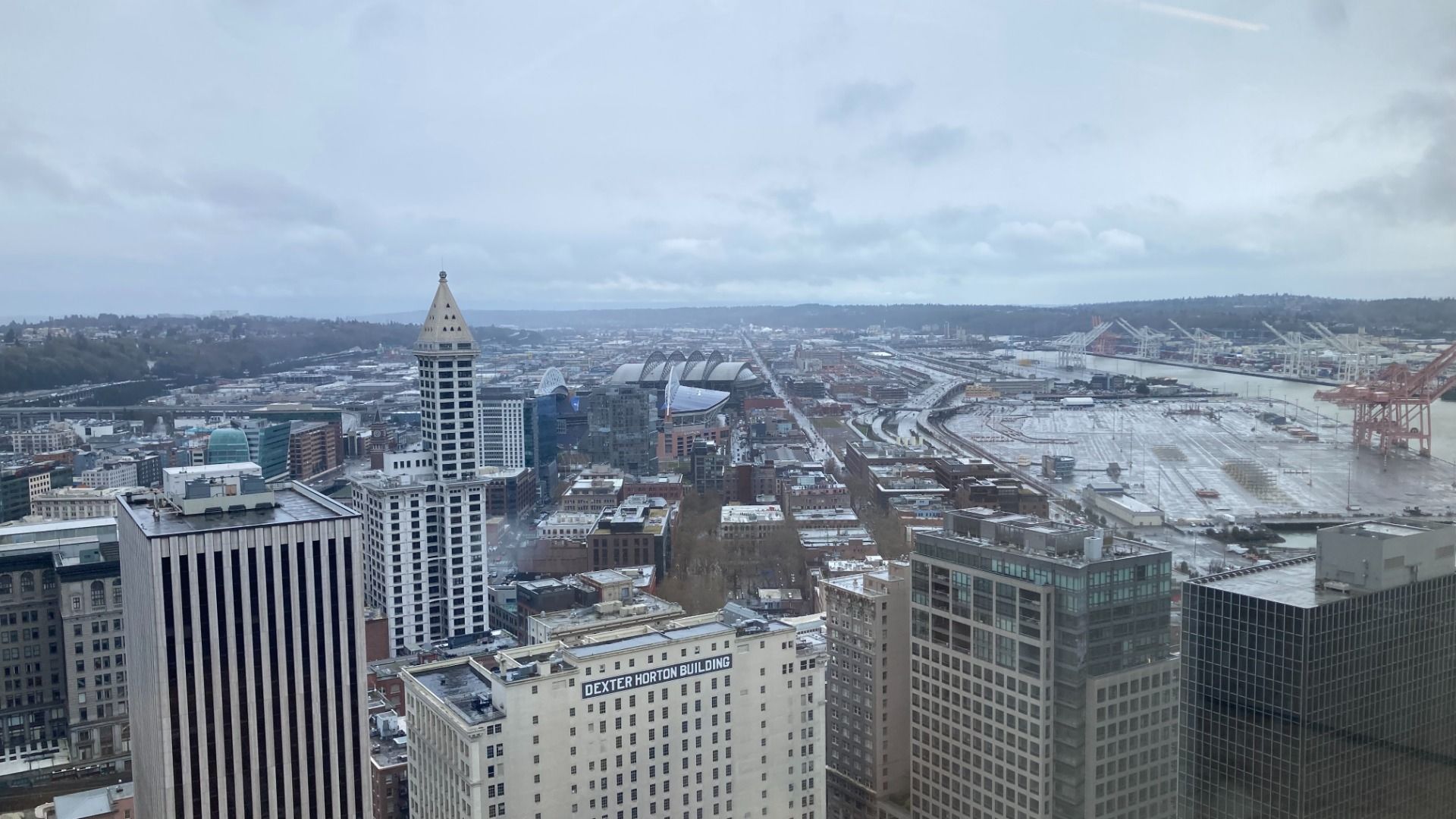 The Seattle skyline as seen from a skyscraper against gray clouds. 