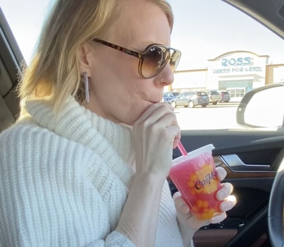 Woman drinking hot pink drink.