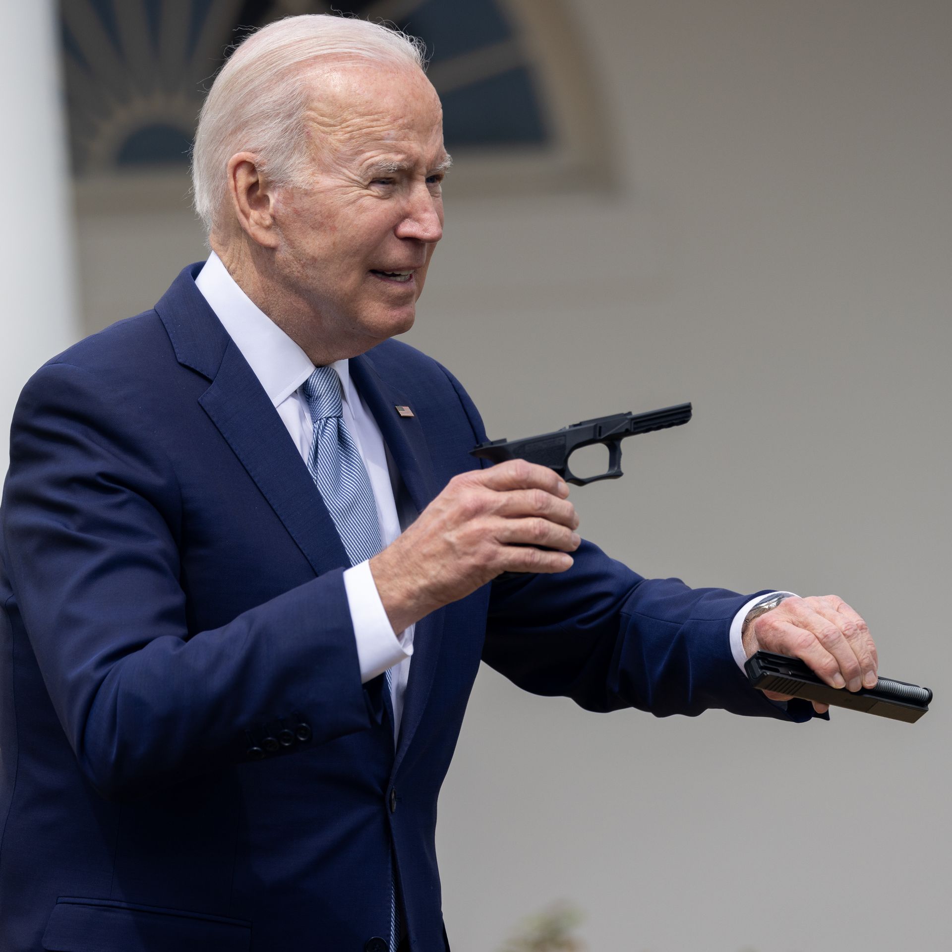 President Biden holds up pieces of a "ghost gun" kit on April 11.