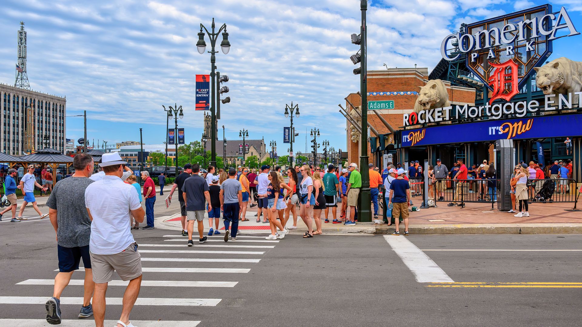 A crowd of people walk into Comerica Park
