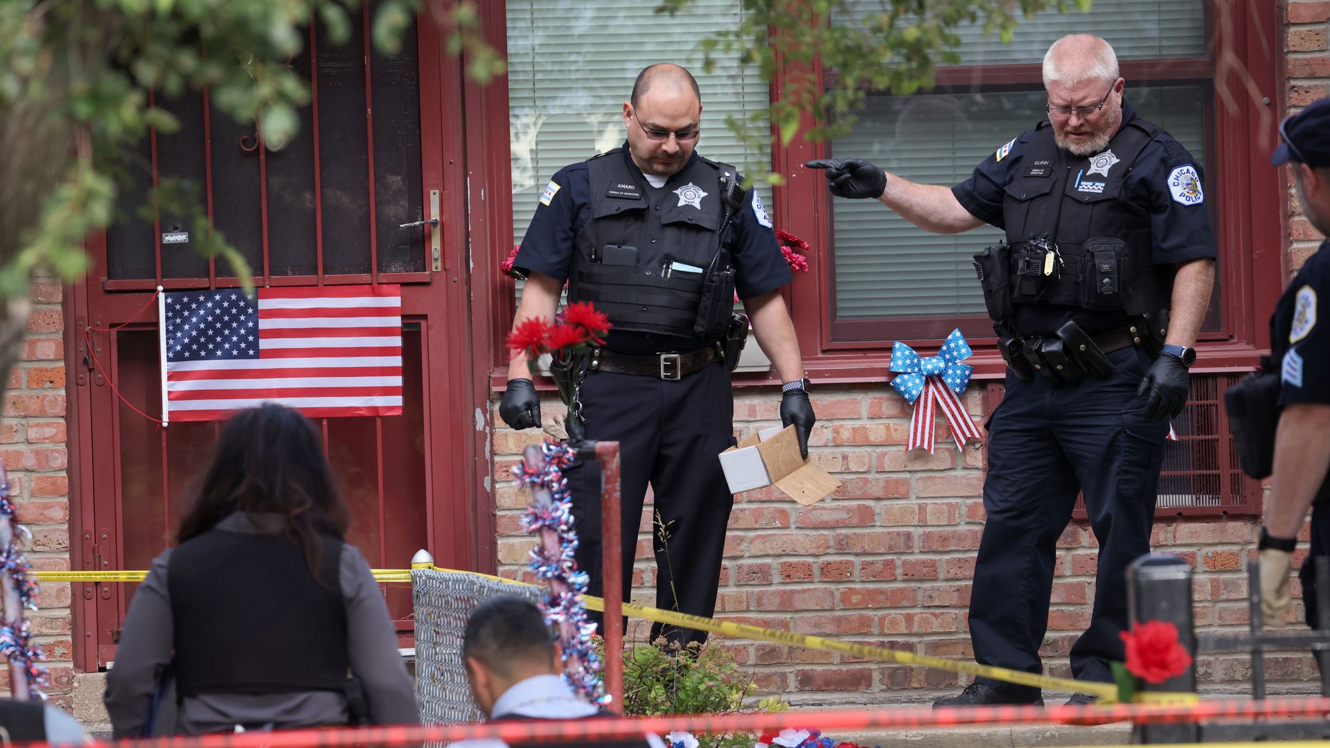 Police investigate a crime scene where three people were shot at a housing complex on June 23, 2021, in Chicago.