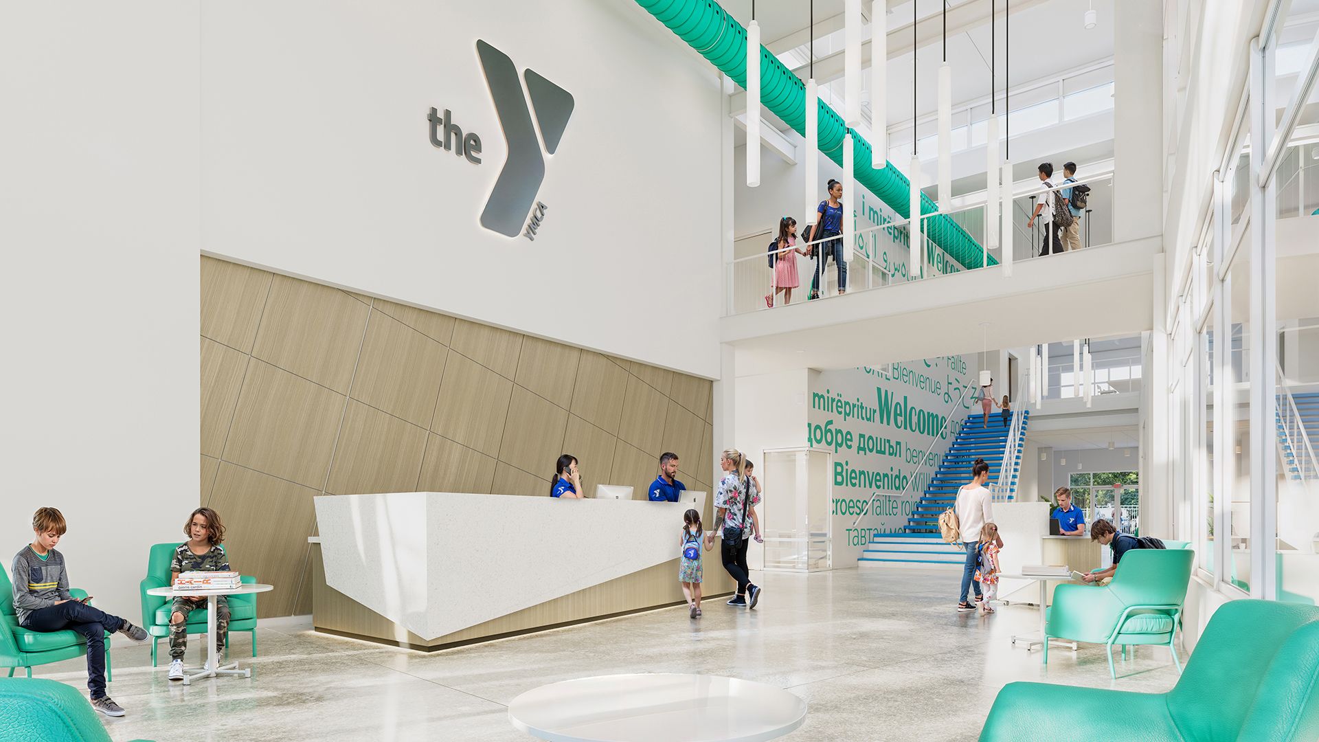 A rendering showing a modern white lobby with green accent chairs. A gray sign above a front desk reads "the Y."
