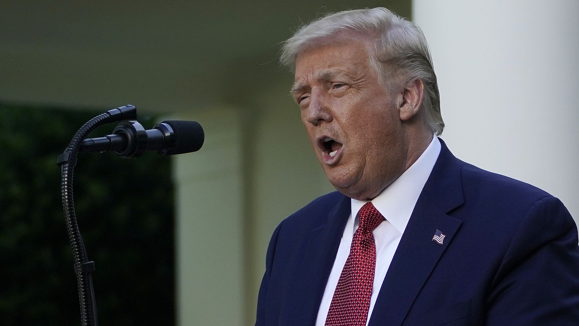 President Trump speaking into a microphone during a press conference
