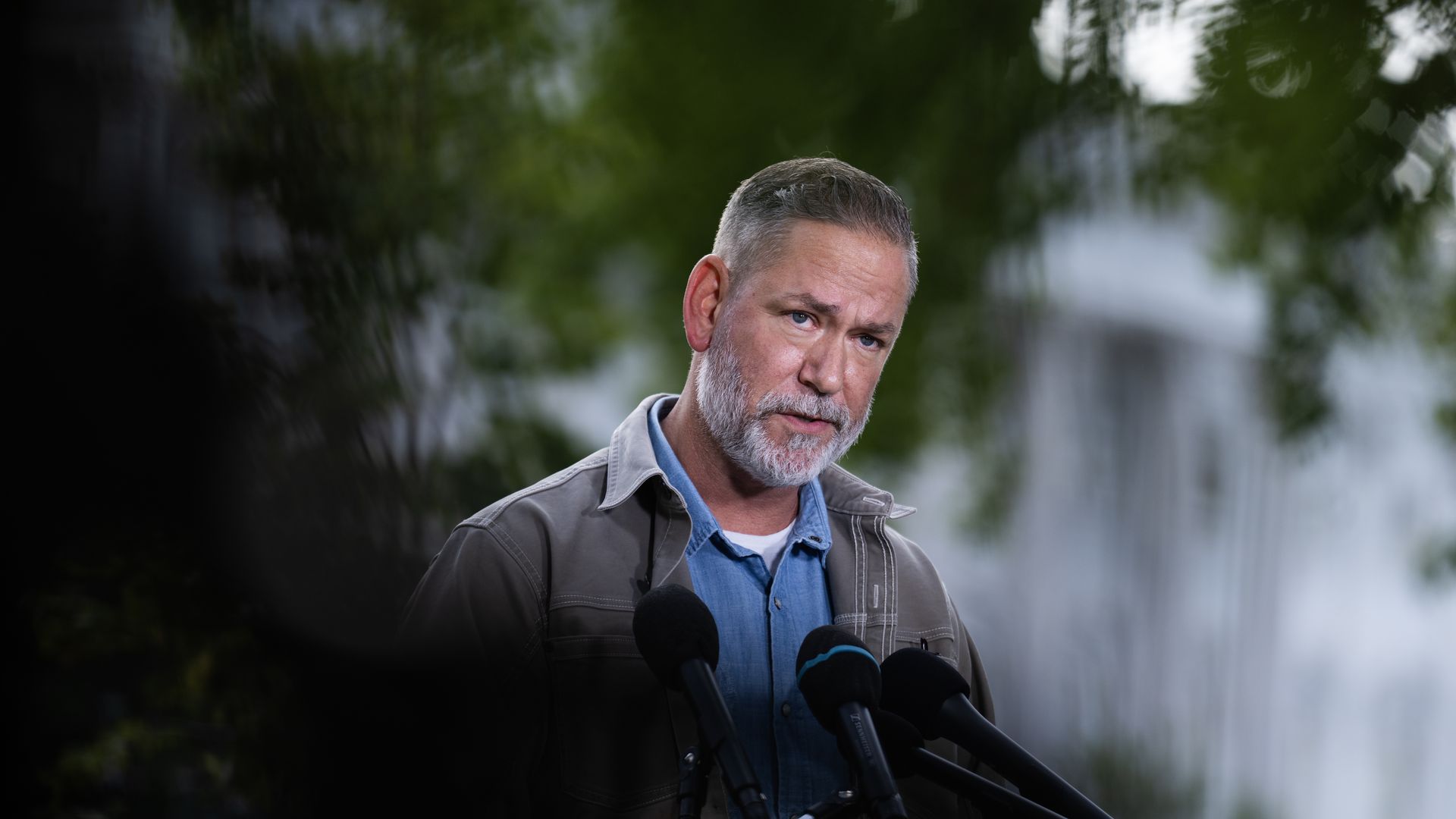 Nebraska independent U.S. Senate candidate Dan Osborn speaks at a group of microphones.