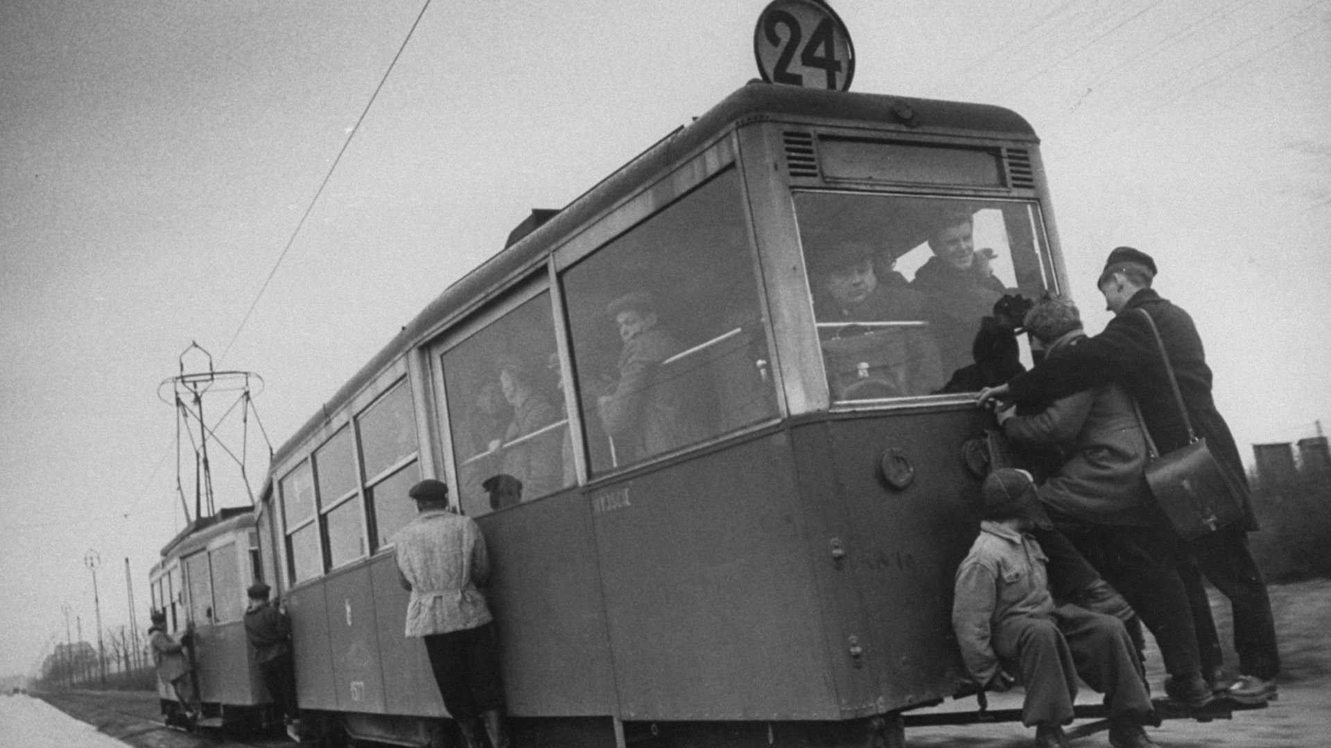 People hanging off a streetcar.