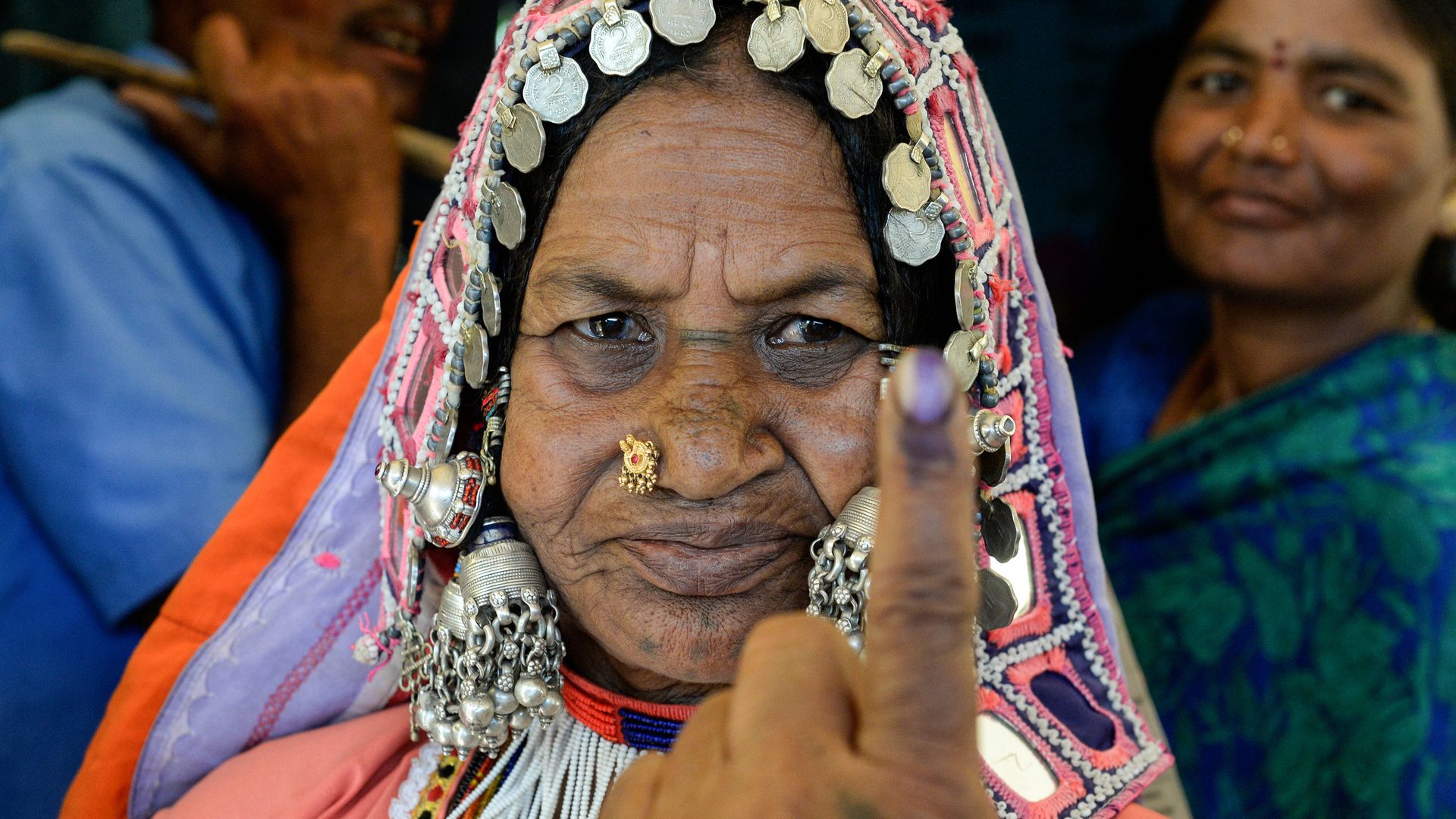 An Indian lambadi tribeswoman shows her ink-marked finger after voting at a polling station during India's election.