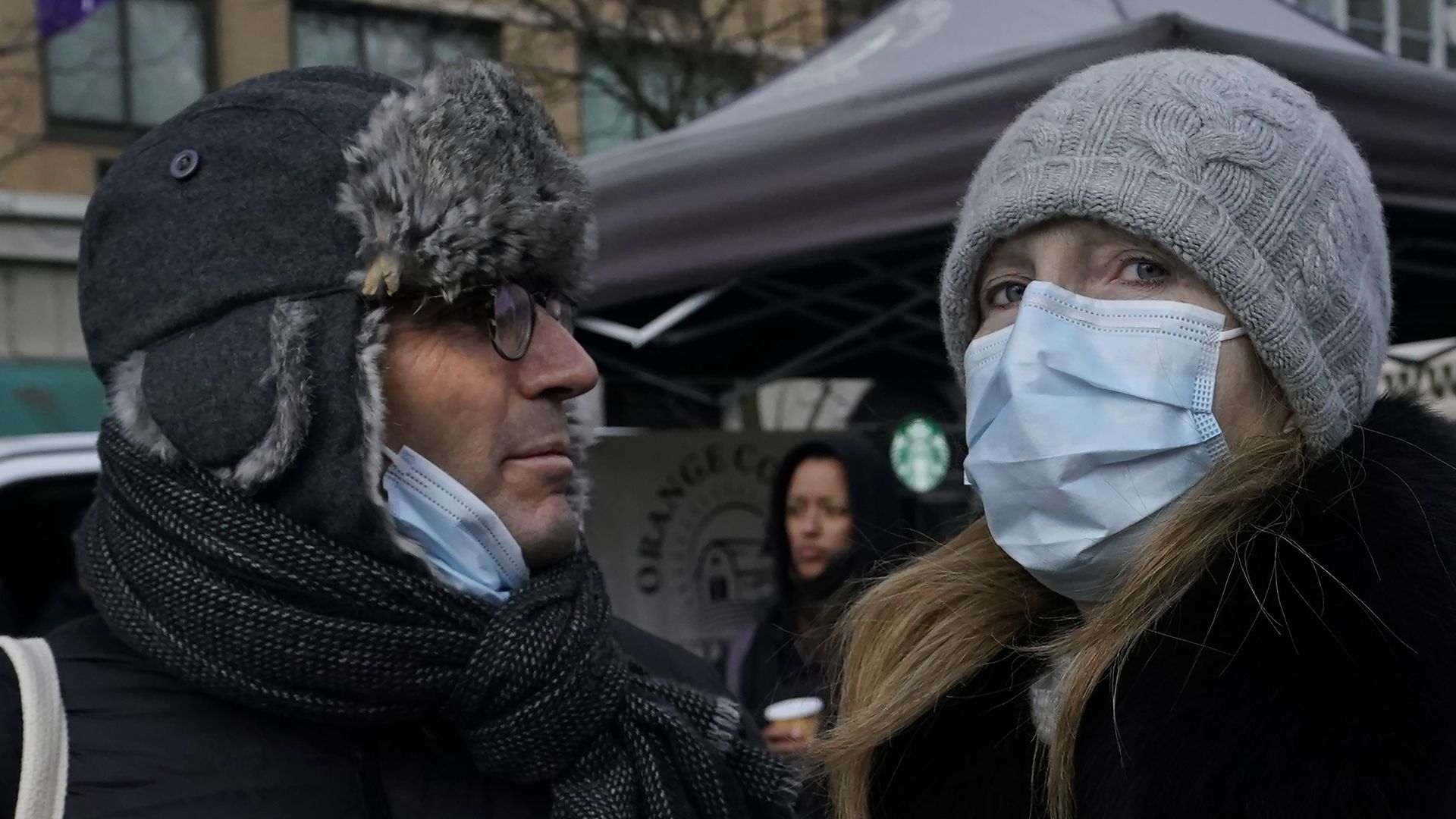 Tourists with face masks walk through Union Square in New York City