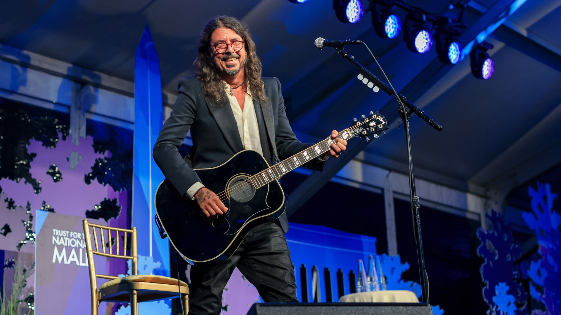 Dave Grohl of the Foo Fighters in a suit jacket with a guitar at the Ball for the National Mall