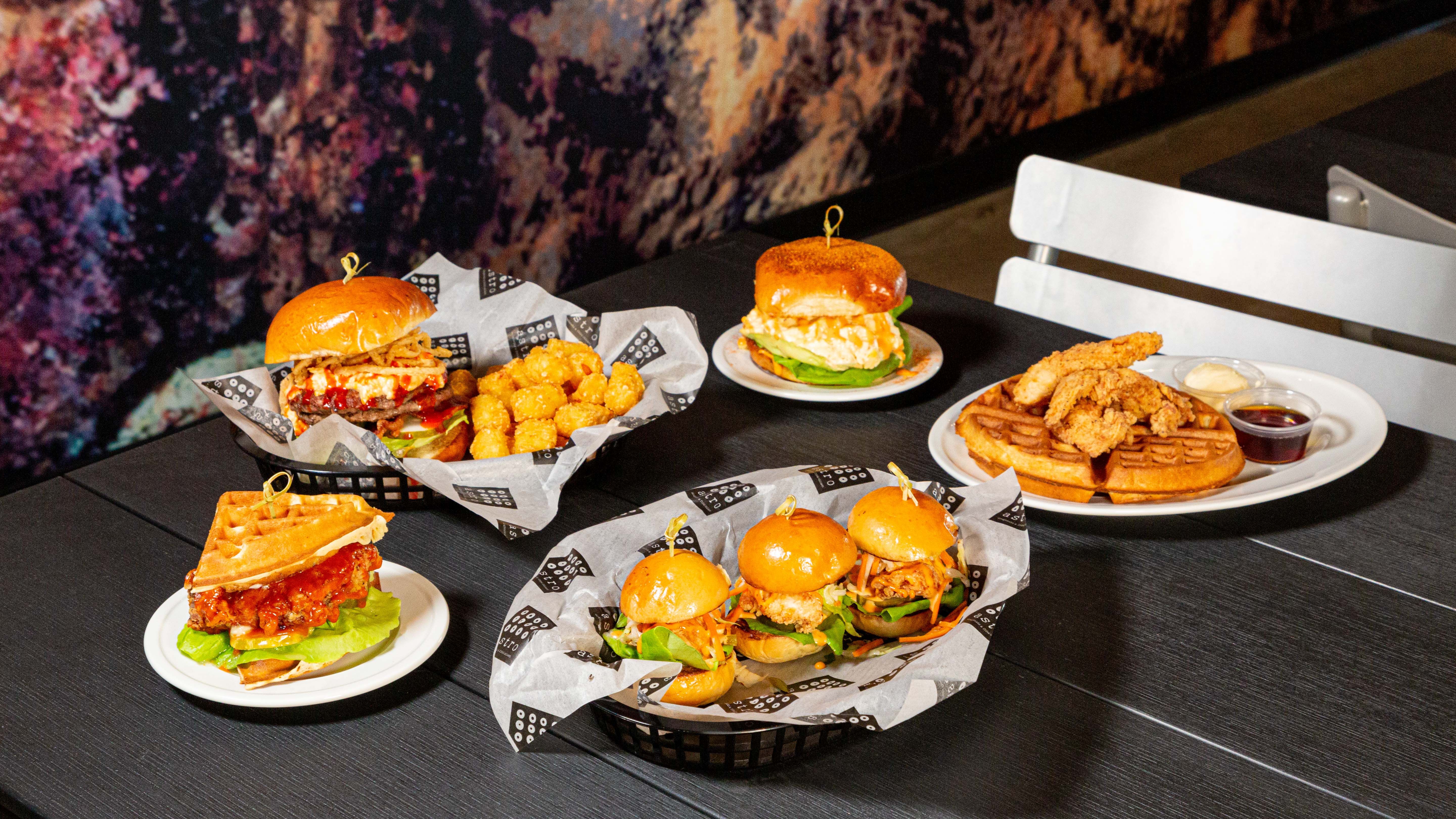 A table heaped with fried chicken sandwiches and sliders.