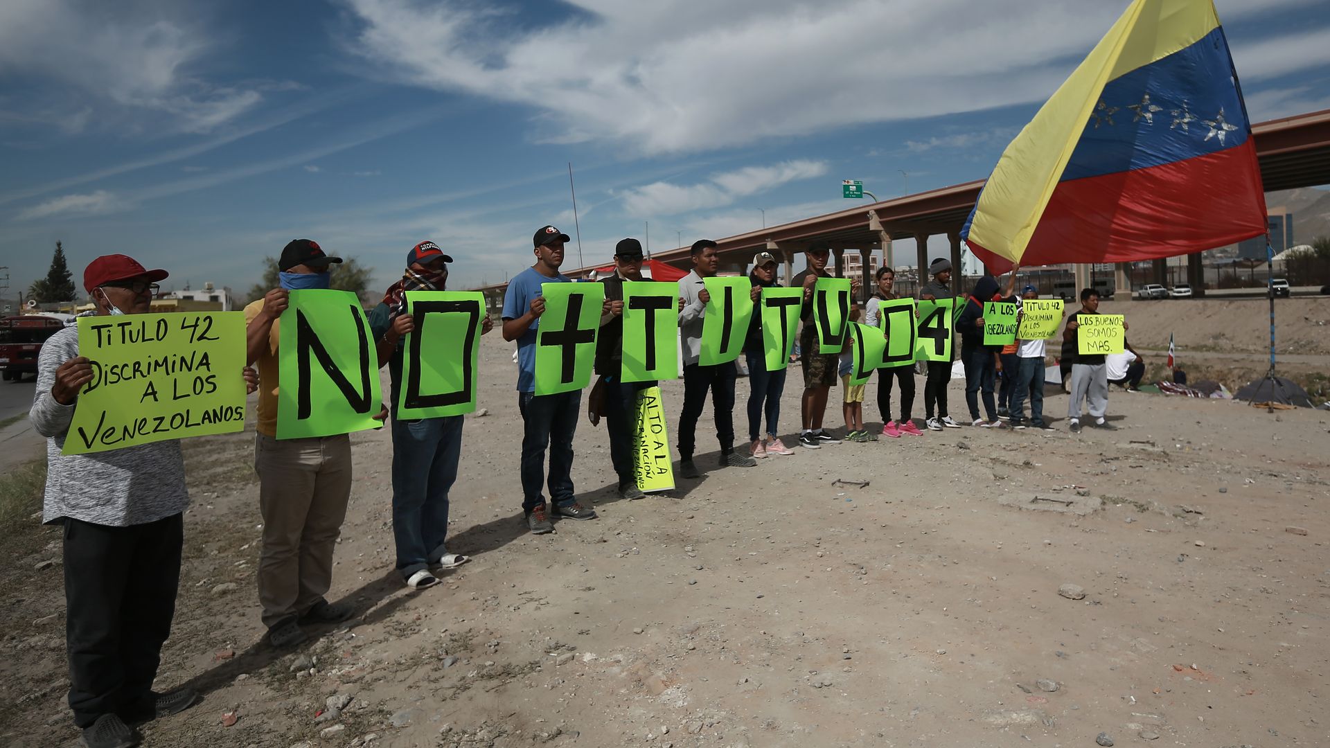 Migrants camping on the U.S.-Mexico border protest Title 42 by holding signs for Border Patrol agents to read.