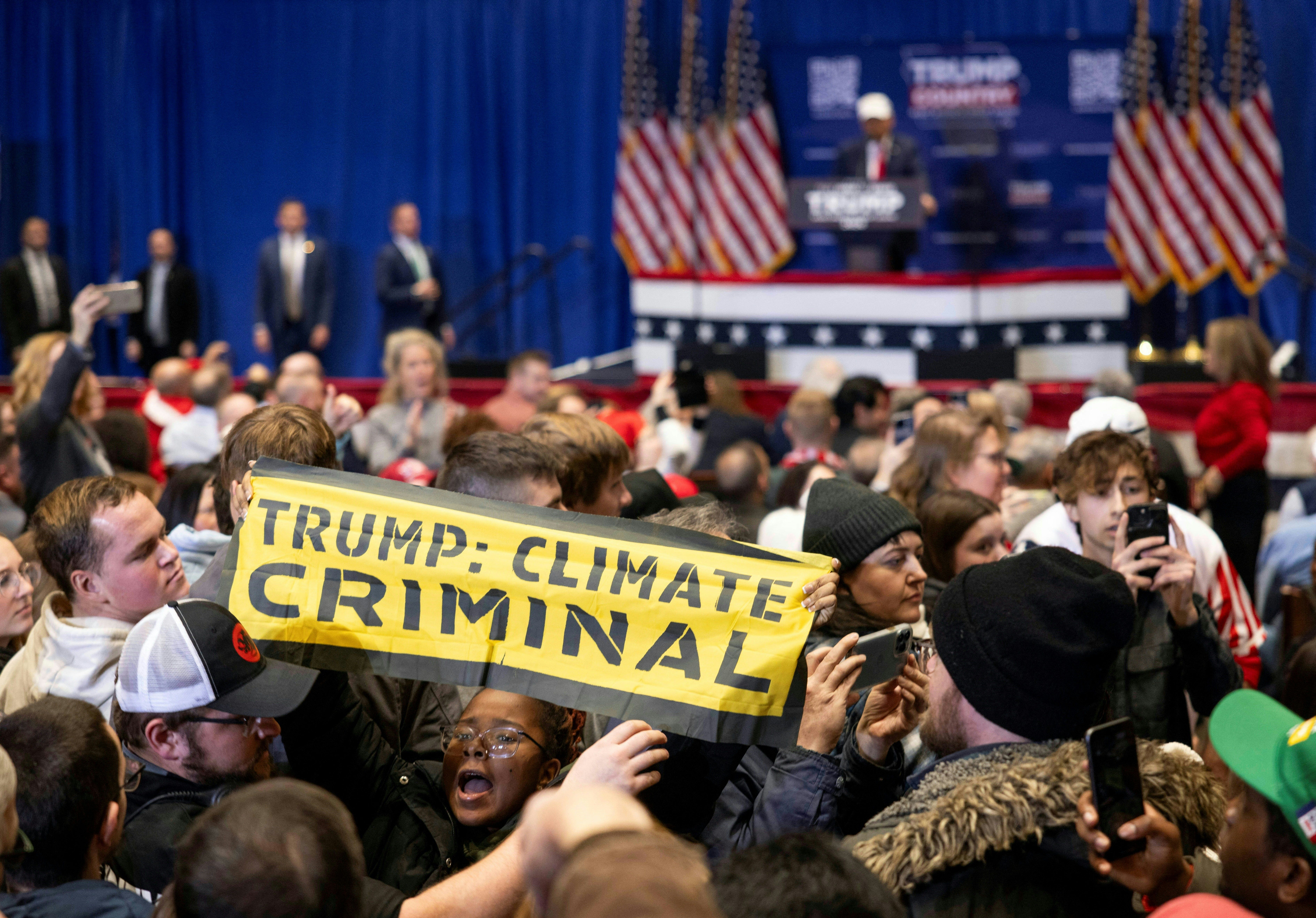  Climate protesters interrupt former US president and Republican presidential hopeful Donald Trump as he speaks at a "commit to caucus rally" in Indianola, Iowa, on January 14, 2024.