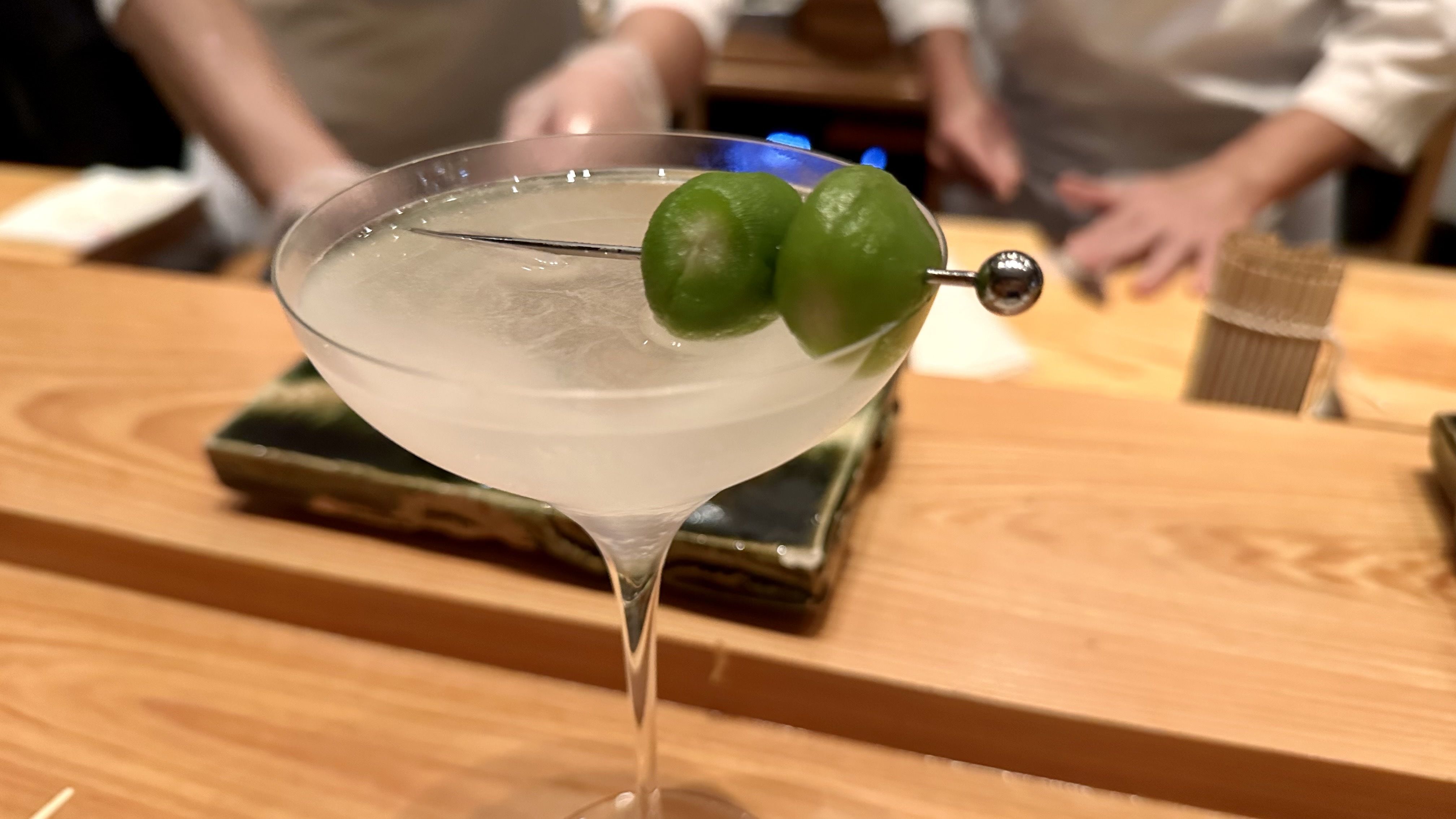 a photo of a martini on a sushi bar top