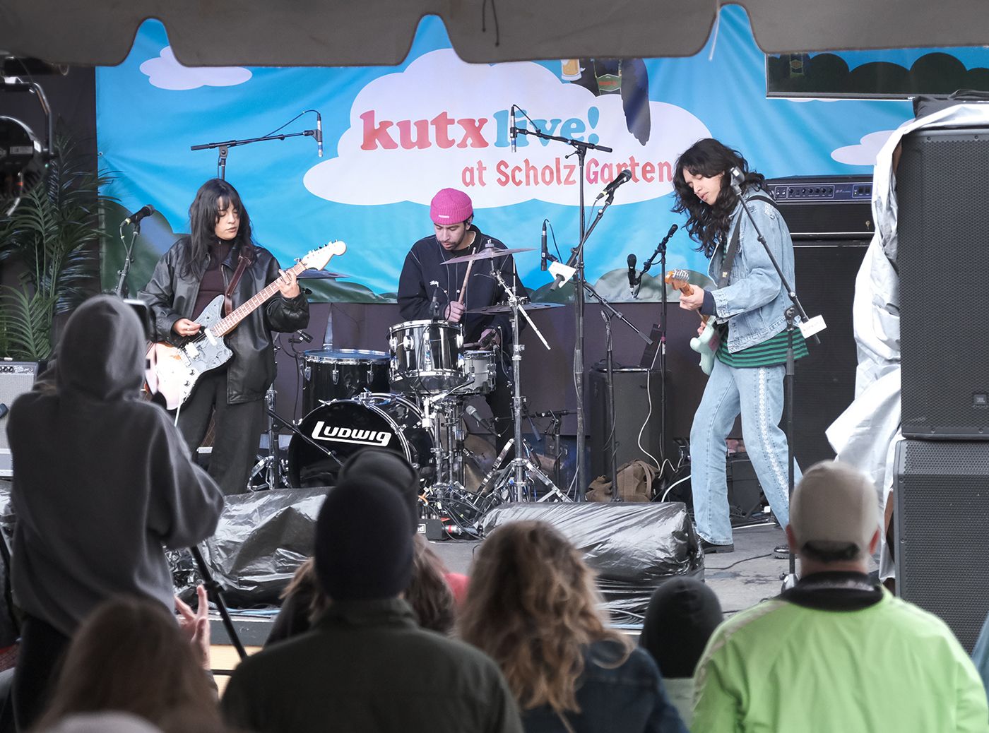 A photo of three musicians performing on a stage.