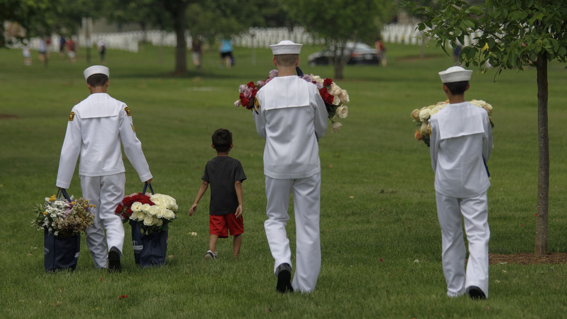 United States Naval Sea Cadets carry flowers to Cemetery Section 33, during a volunteer event ahead of Memorial Day at Arlington National Cemetery