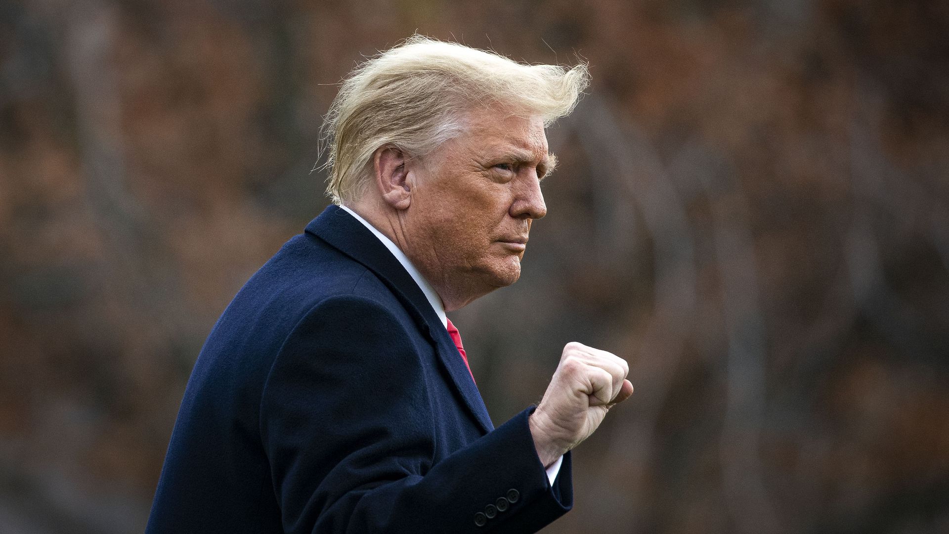 Donald Trump walking outside making a triumphant fist